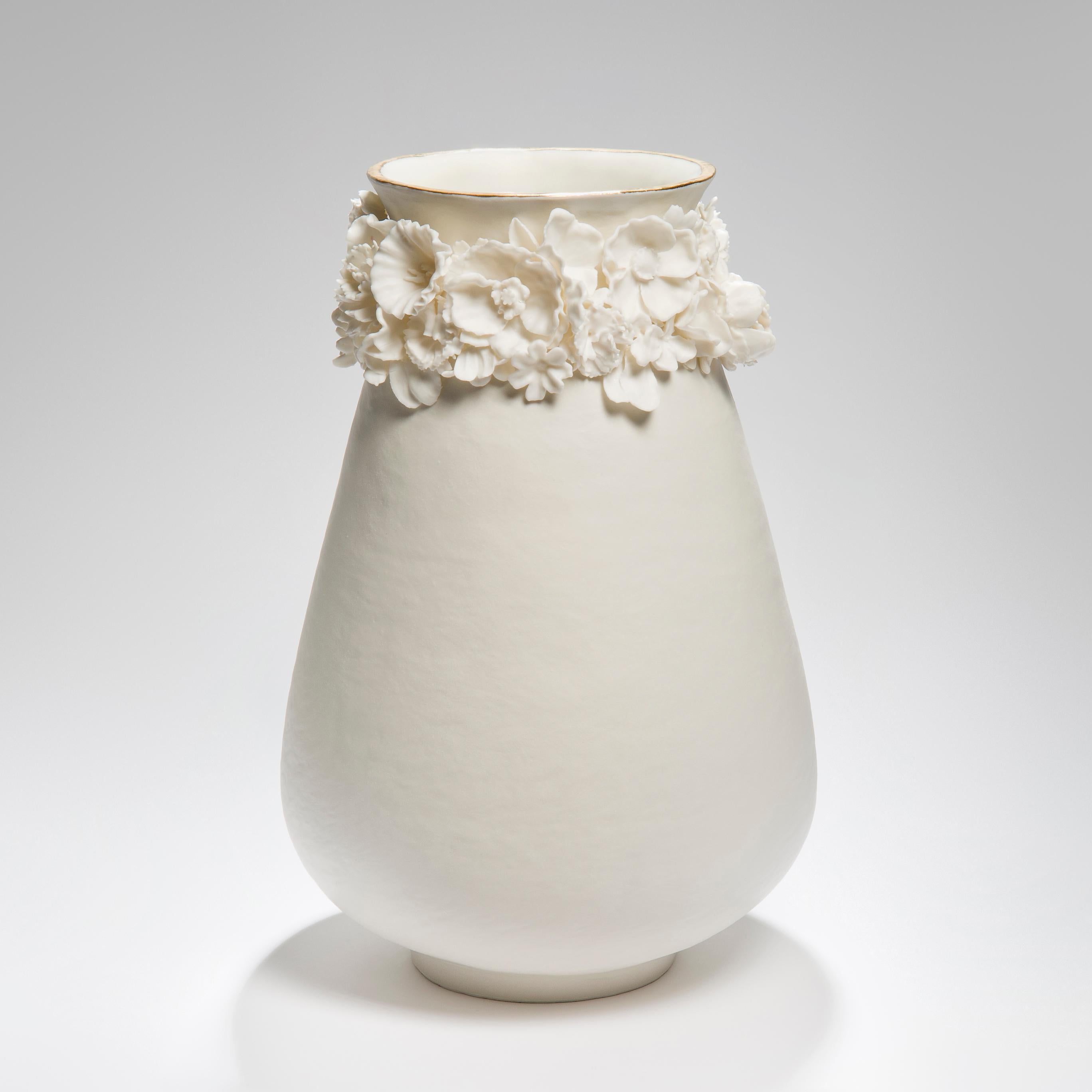 Forget Me Not tall vase is a unique artwork, handcrafted and made by the British artist Amy Hughes. Hughes starts by coiling and hand-building the main form, which is then adorned with delicate flowers created in Parian. The piece is finished with a