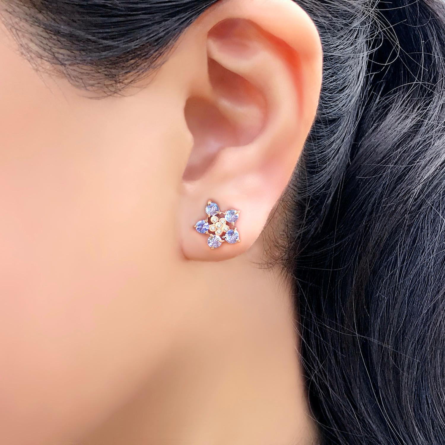 The Forget-Me-Not Tanzanite flower studs with tanzanites and diamonds define effortless and playful elegance with handcraft charisma. This pair each features 5 round 3mm prong set Tanzanite in sparkly purple surrounding 6 round 1mm bezel set
