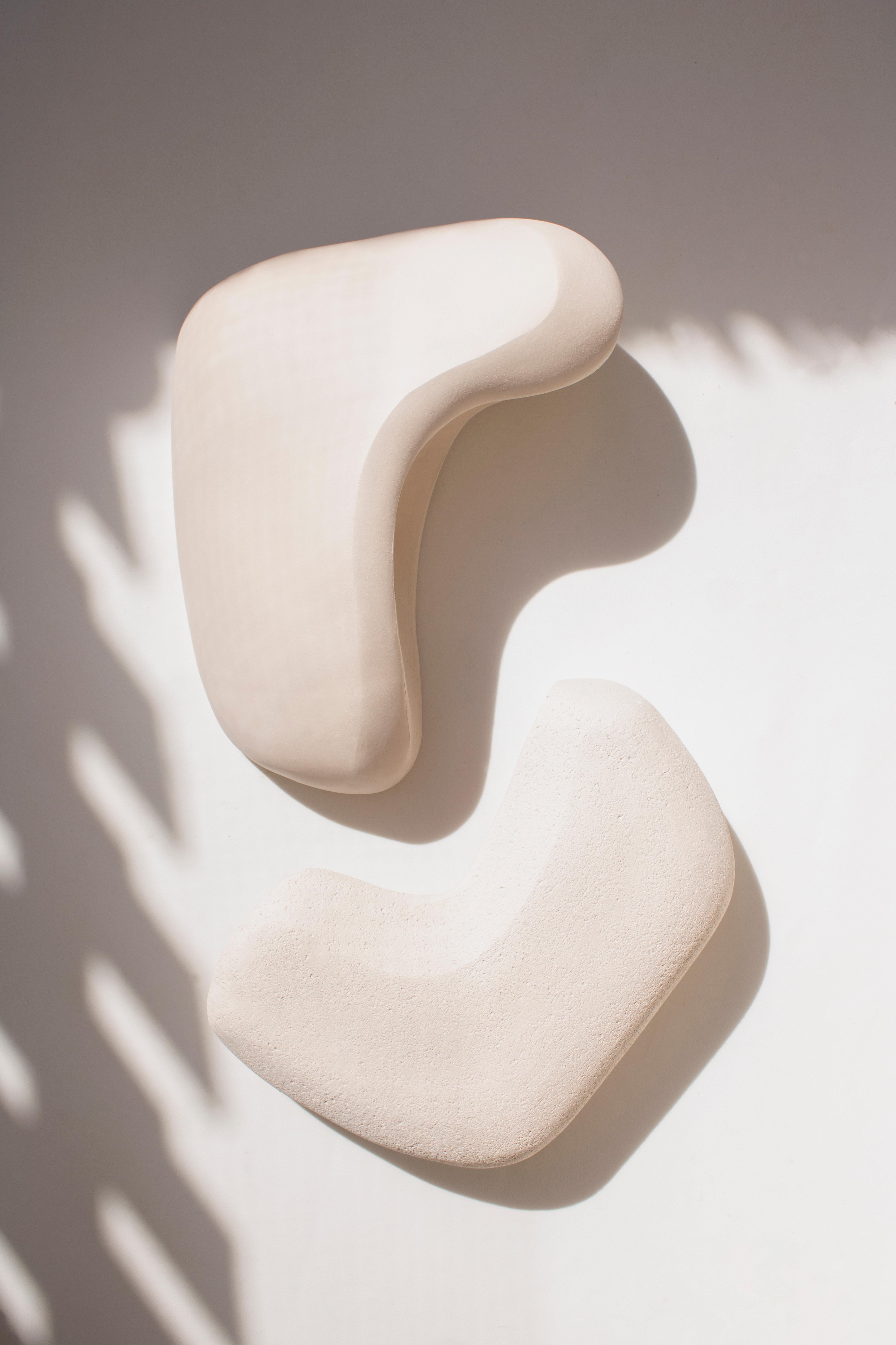 Form No.007 is a set of sculptural ceramic wall lamps from the Forms Collection. The piece is meticulously hand-built to explore the harmony in asymmetry. Its unique appeal lies in its abstract contours and organic shape that not only serve as an