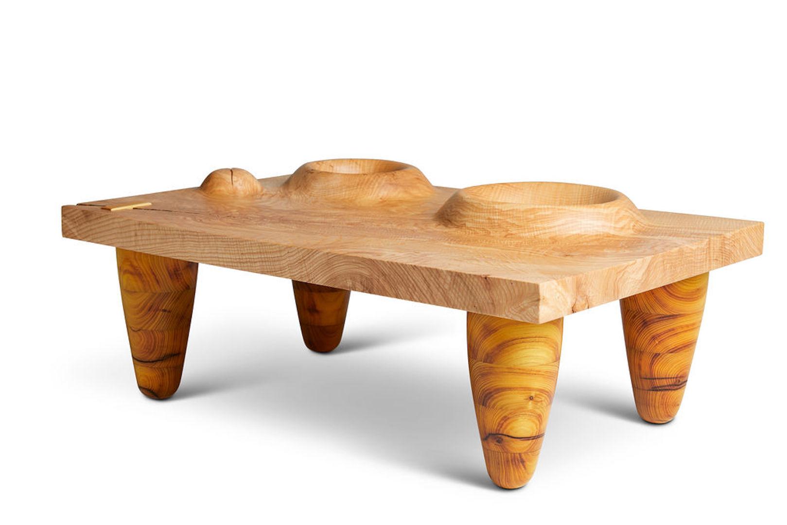 Sculptural coffee table with a hand carved figured ash top and turned osage orange legs.