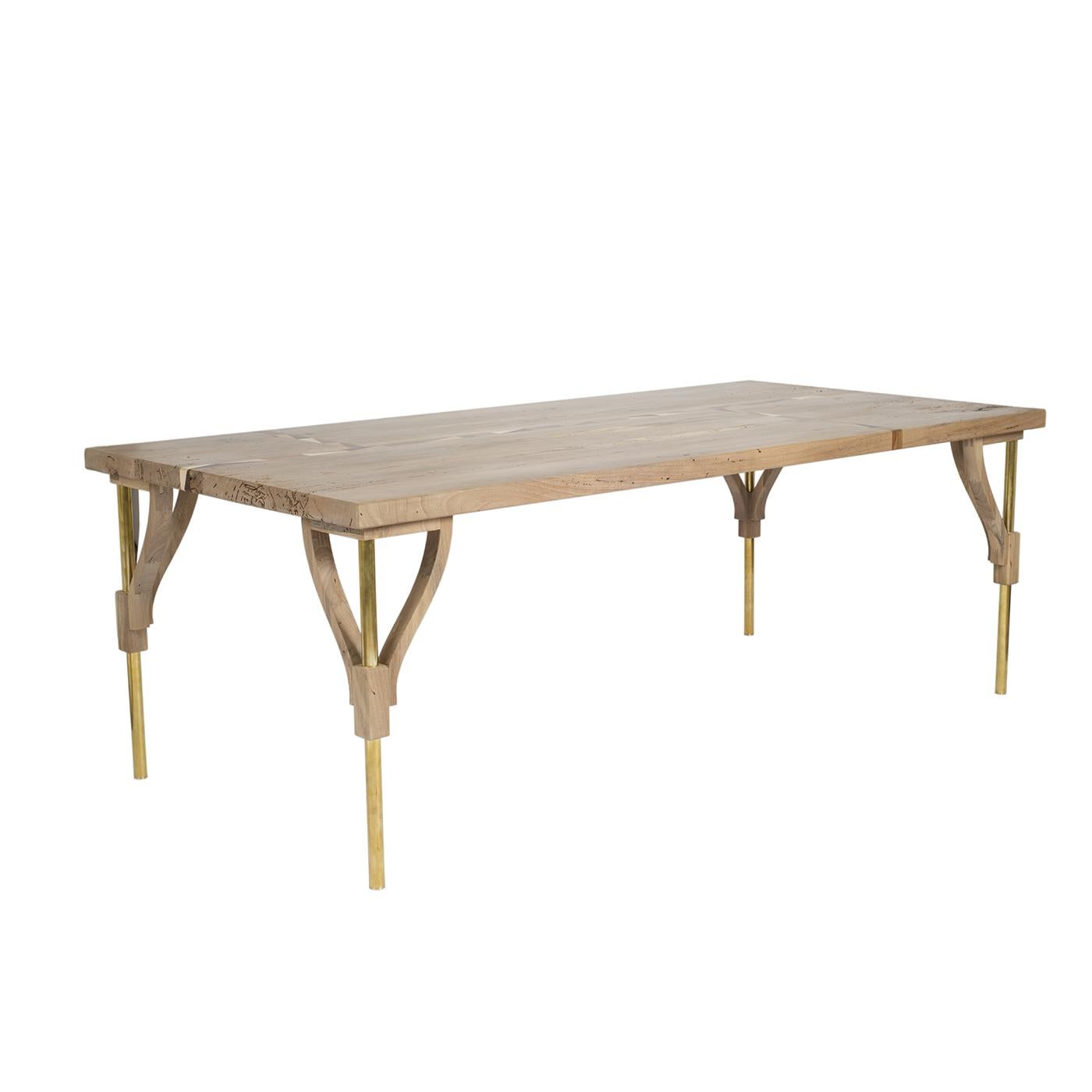 Meticulously crafted with by expert craftsmen, this table is a sublime accent in a contemporary and rustic interior. The rectangular top is entirely fashioned of solid walnut wood complete with 10mm wide inlays. The slender brass legs are embedded