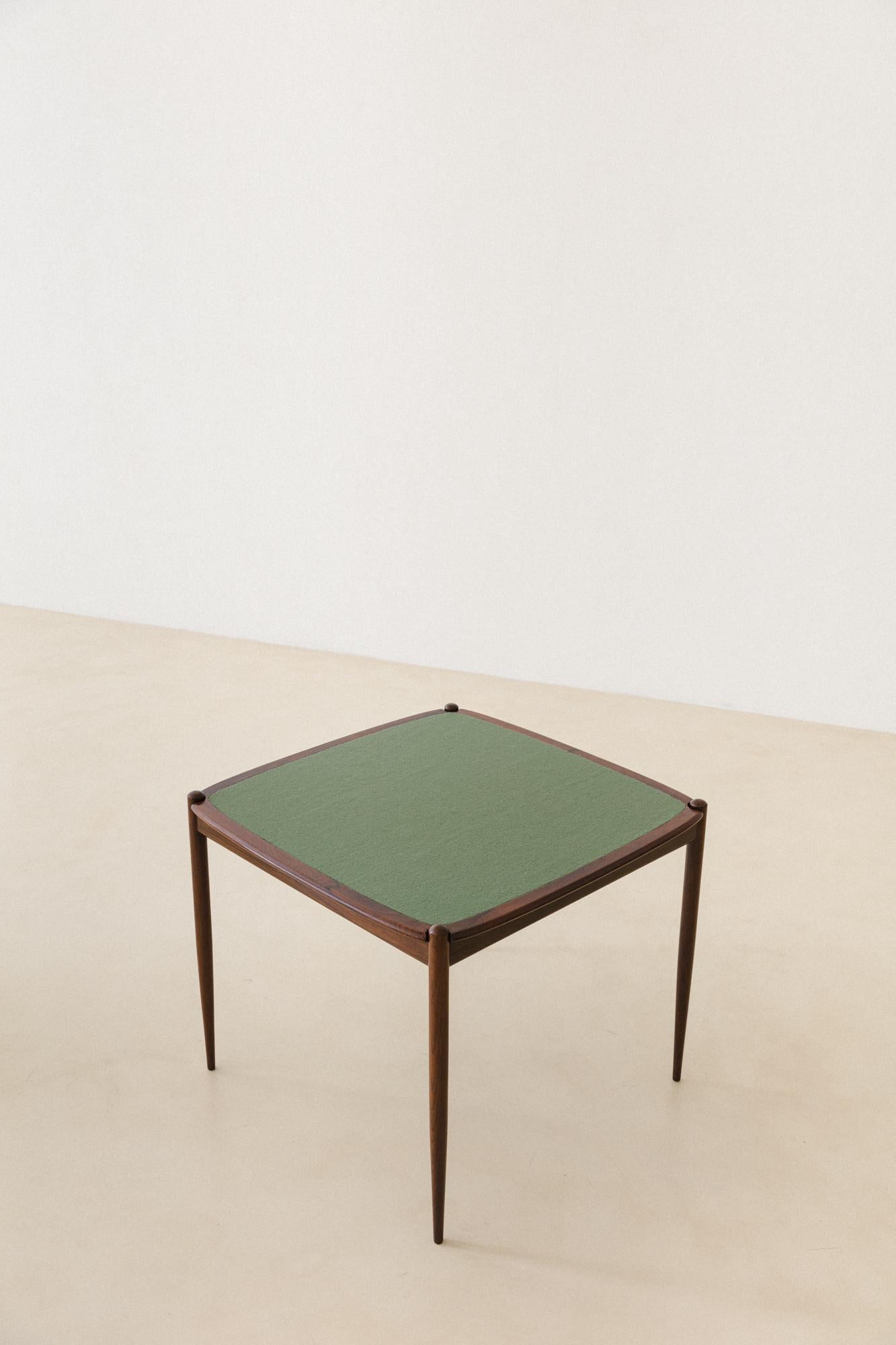 This game table was produced by the Brazilian Forma S.A. Móveis e Objetos de Arte in the 1950s. The piece is made of a Rosewood structure and the top can be used on both sides: one in rosewood veneers, and other covered in a gorgeous green