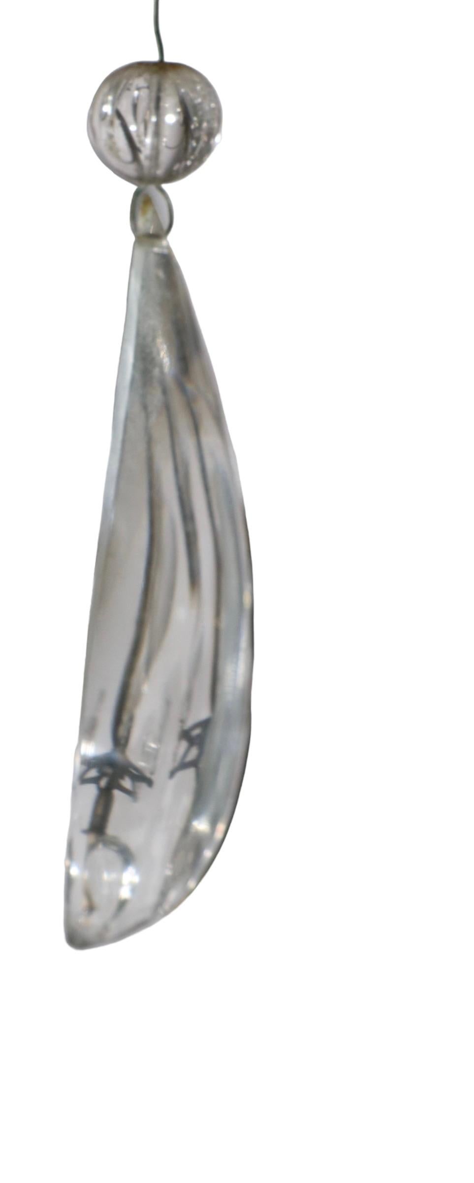 Spectaculaire luminaire suspendu provenant du détaillant de renommée mondiale, Charles J. Winston. Le lustre présente une structure en laiton massif, garnie de perles de cristal enfilées à la main et habillée de gouttes de cristal facetté et de