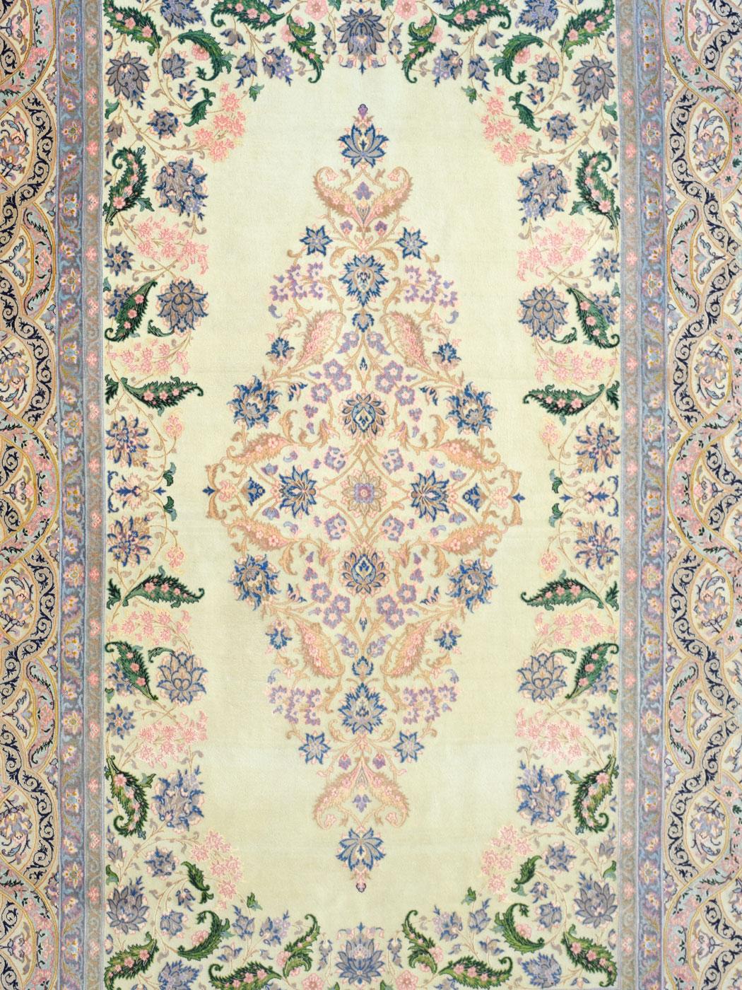 Measuring 5’ x 7’3”, this ornate Persian Isfahan carpet features a hand-knotted weave and complex border in pinks, purples, and greens. Illustrating a classic Isfahan Garden scene, this carpet features a large central medallion detailed by