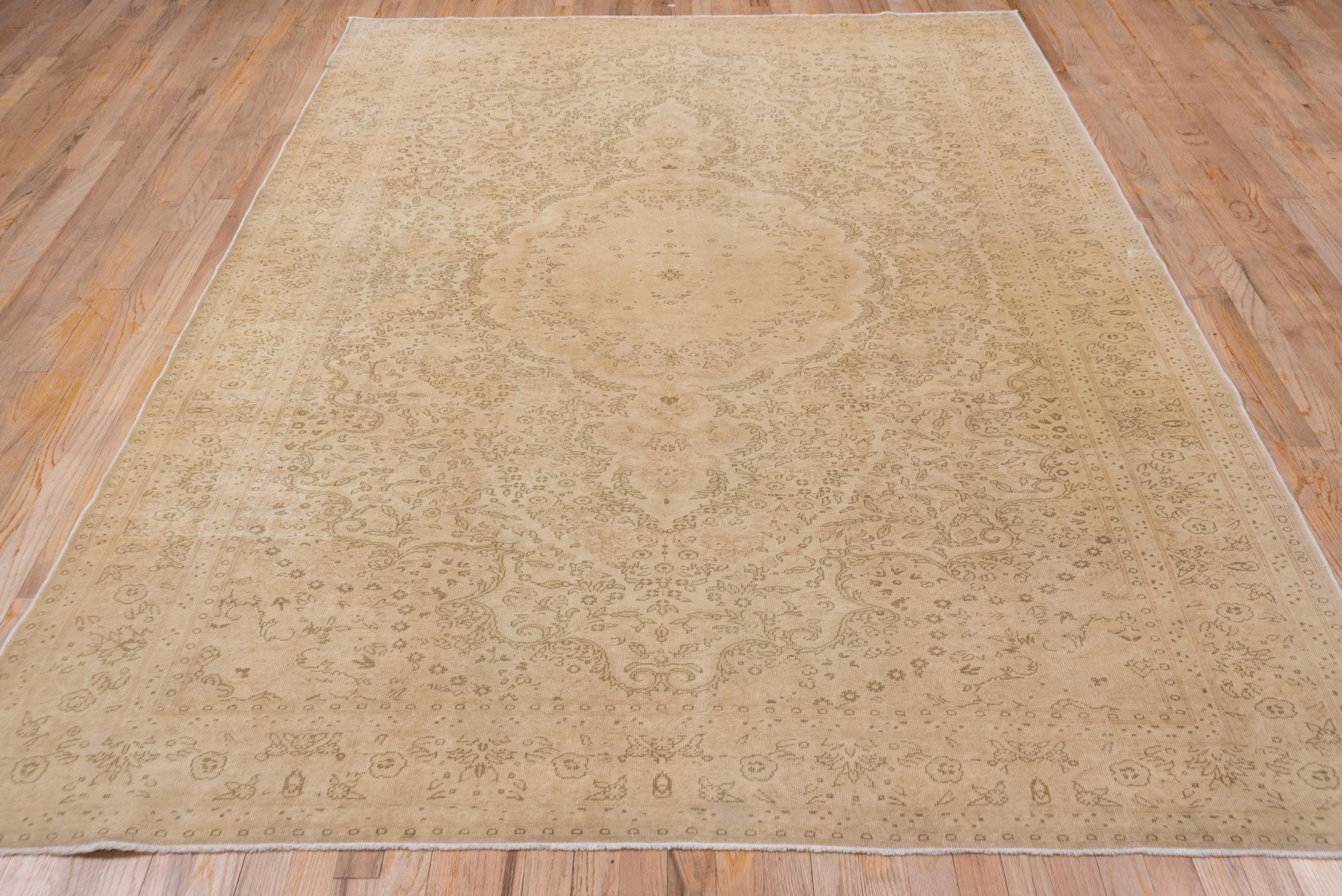 Questo tappeto urbano turco orientale, dalla tessitura moderatamente fine, presenta un segmento di foglie di alloro ricurvo delineato al centro aperto con piccole foglie e angoli lobati e arabescati, il tutto su un fondo avorio crema con decorazioni