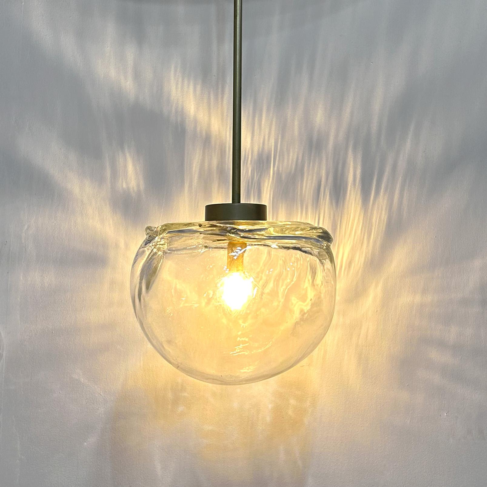 Beams of light radiate through this organic shaped orb and are cast onto surrounding surfaces. The pattern and texture of the hand-made glass is reminiscent of how water, stone and ice formations occur in nature.

SPECS
- Wired to UL standards
-