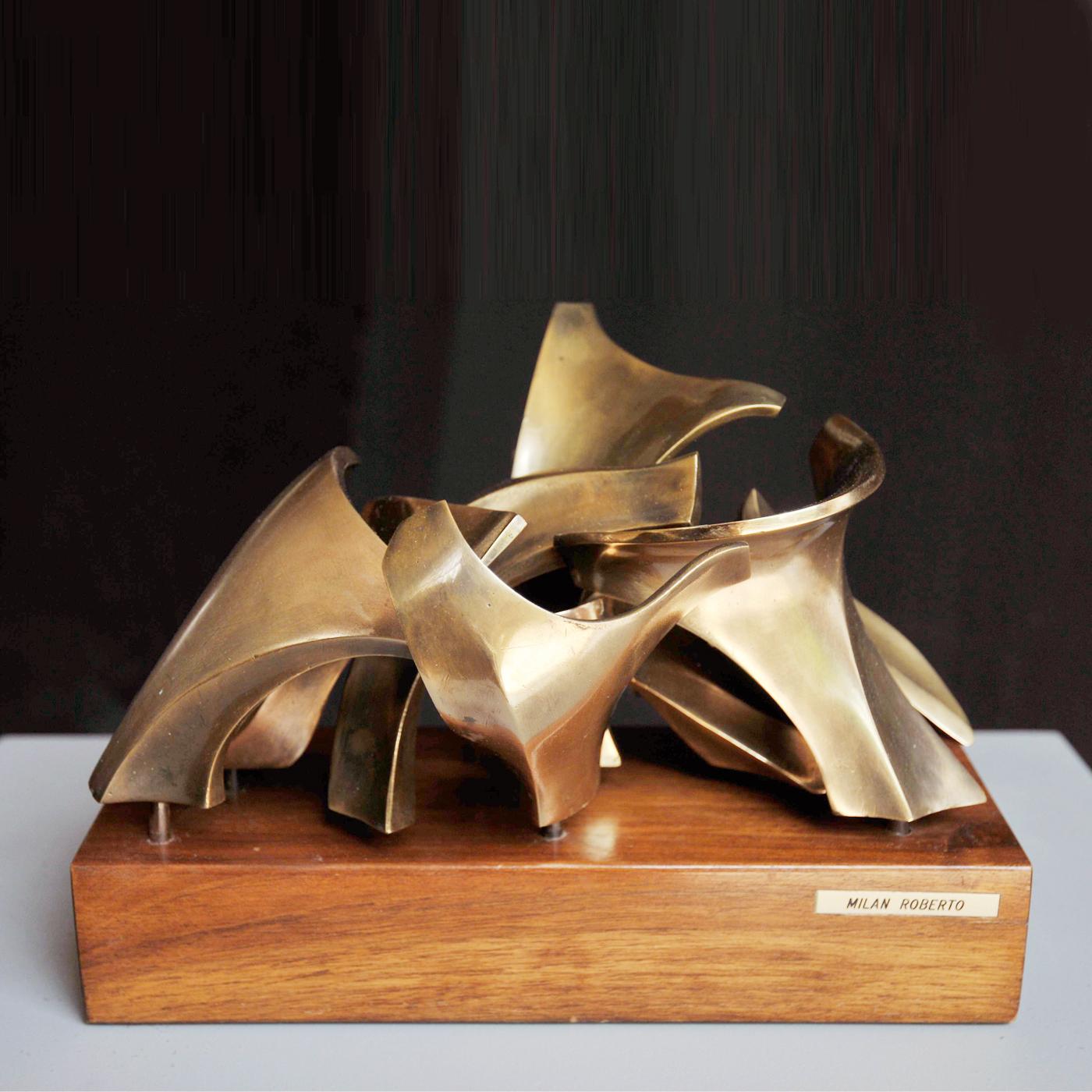 Bronze sculpture with free rounded forms resting on a wooden base. The single elements, achieved through a traditional bronze casting process, evoke movement due to their suppleness which molds to the surrounding spaces. A luminous and modern art