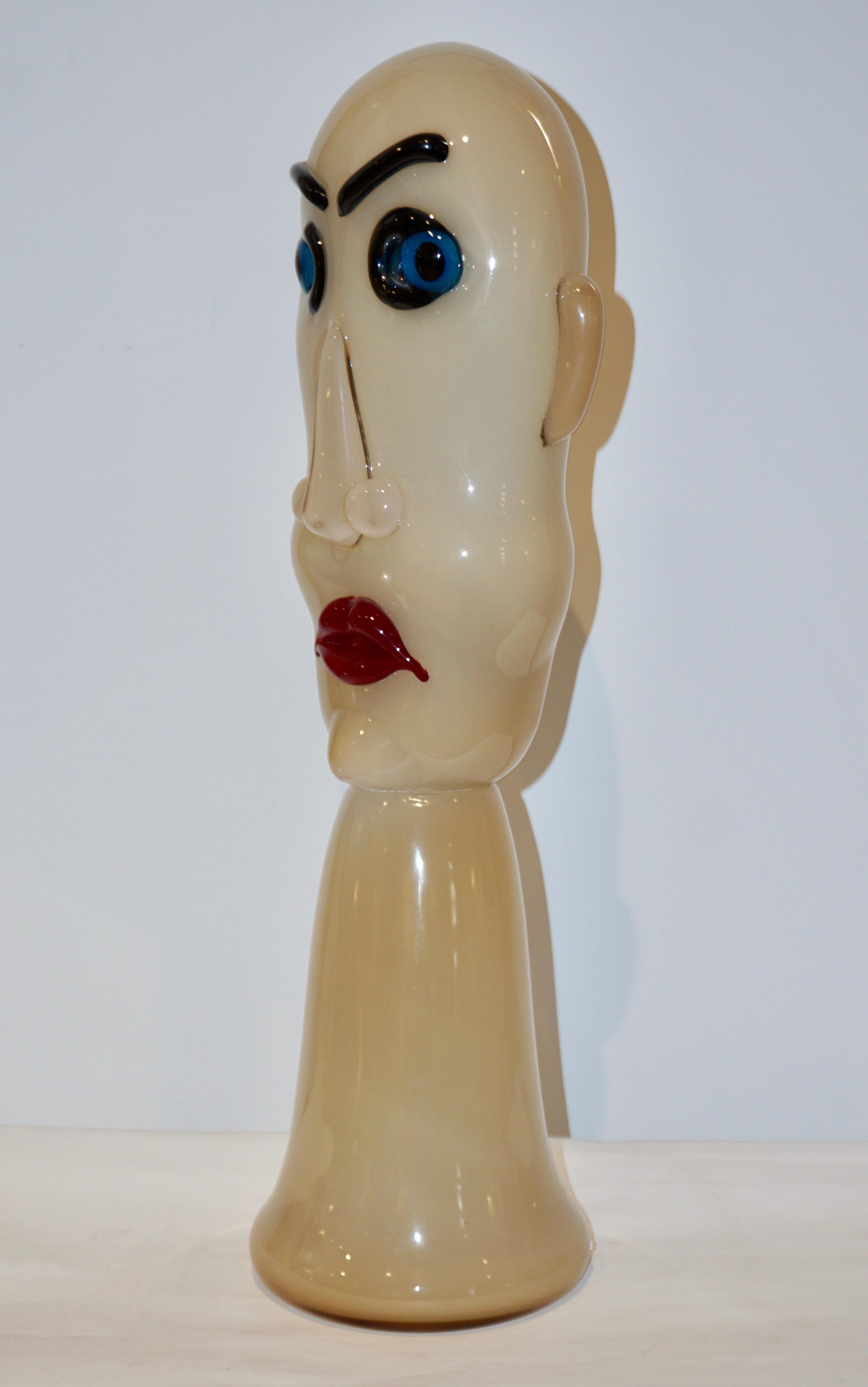 One 1980s, modernist dynamic, comic mouth blown head sculpture in colored Murano glass, in ivory milk white, the face with blue eyes and red lips. This production has been very limited, each piece individually crafted so that each head is different