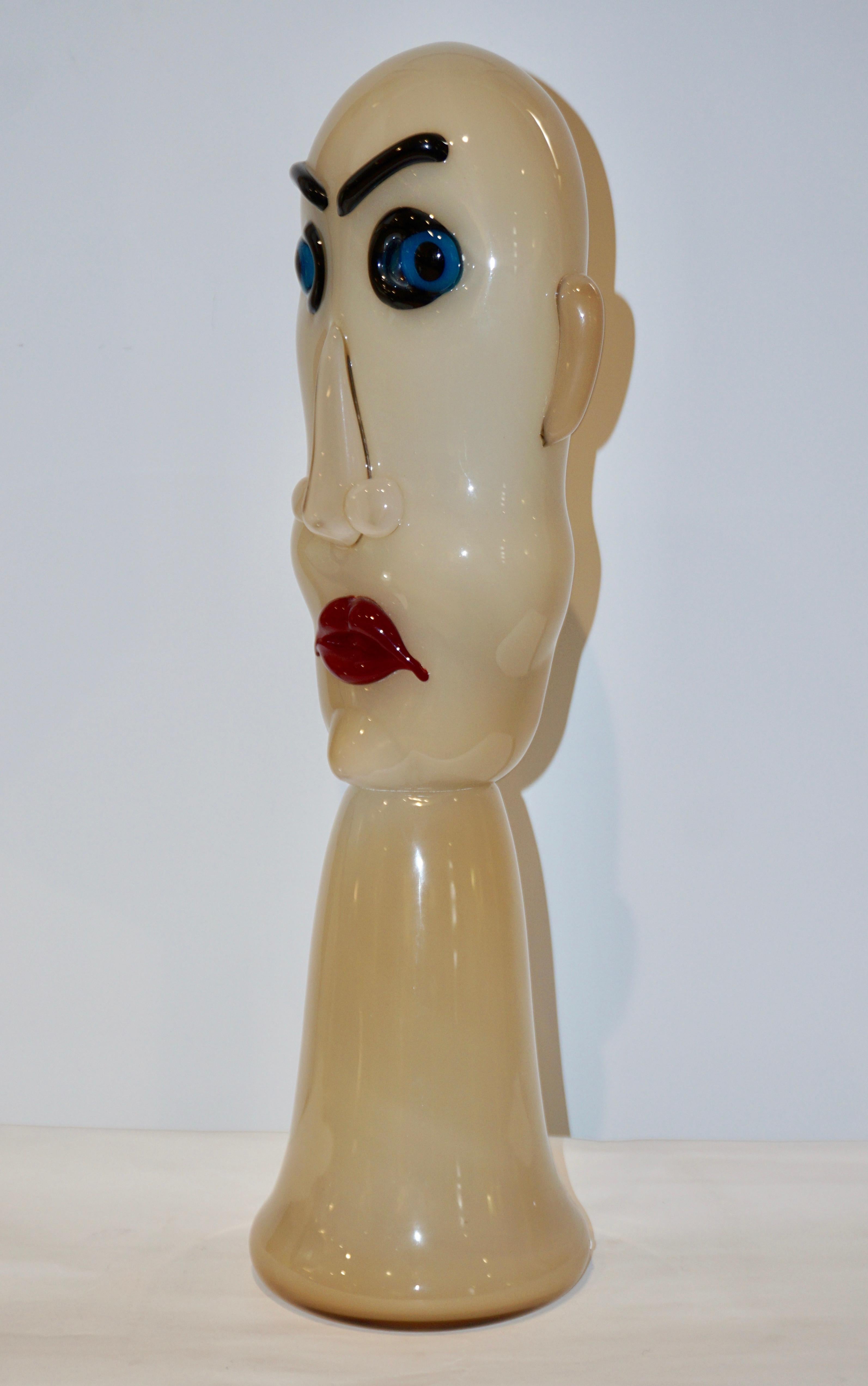 Una escultura de cabeza soplada de la década de 1980, modernista dinámica y cómica, de cristal de Murano coloreado, en blanco leche marfil, la cara con ojos azules y labios rojos. Esta producción ha sido muy limitada, cada pieza se ha elaborado