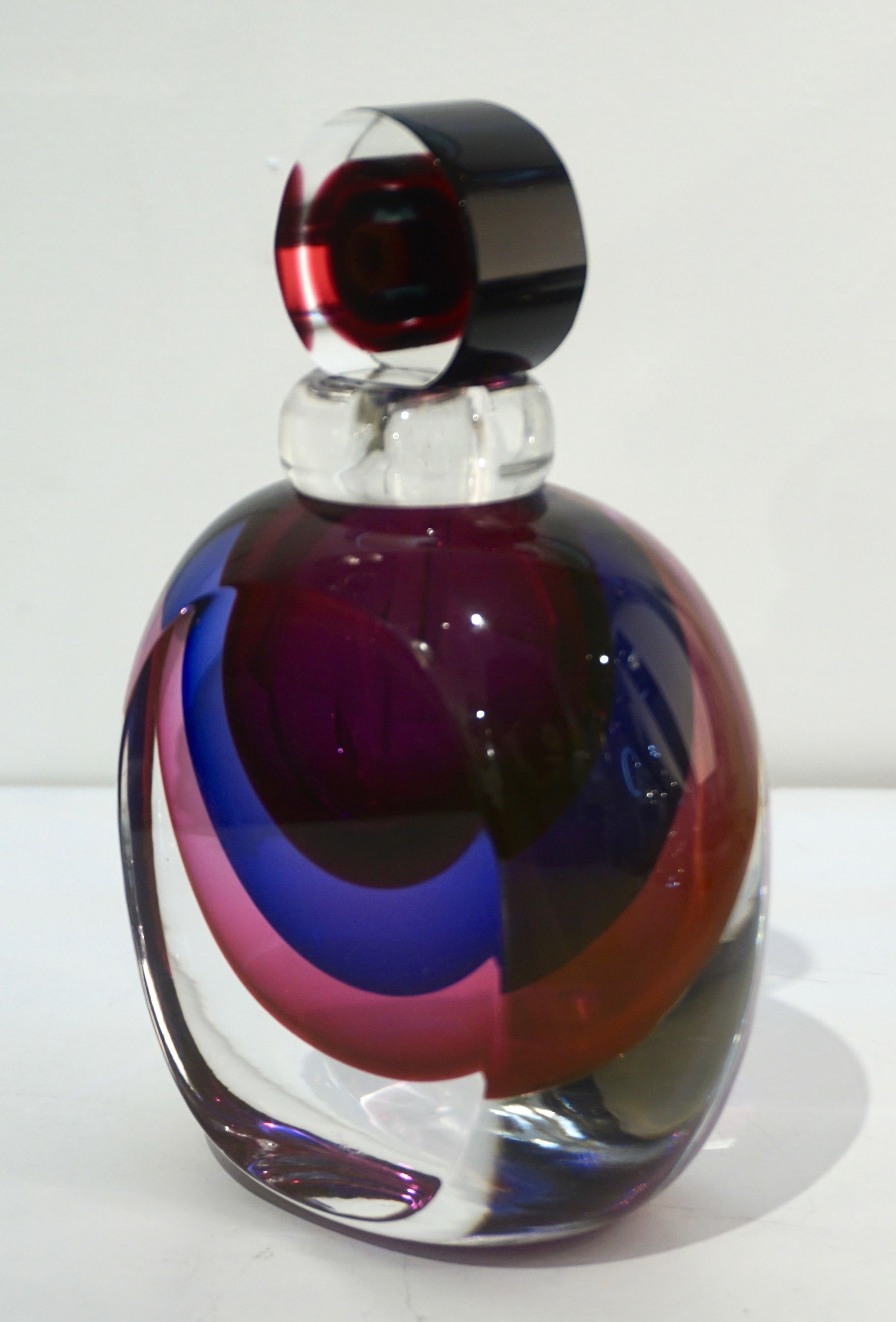 A vintage Murano glass perfume bottle of an interesting organic oval shape with flat front and back and unusual candy flat drop stopper, the body and the stopper each worked with the Venetian technique Sommerso: the 3 colors, purple, royal blue and
