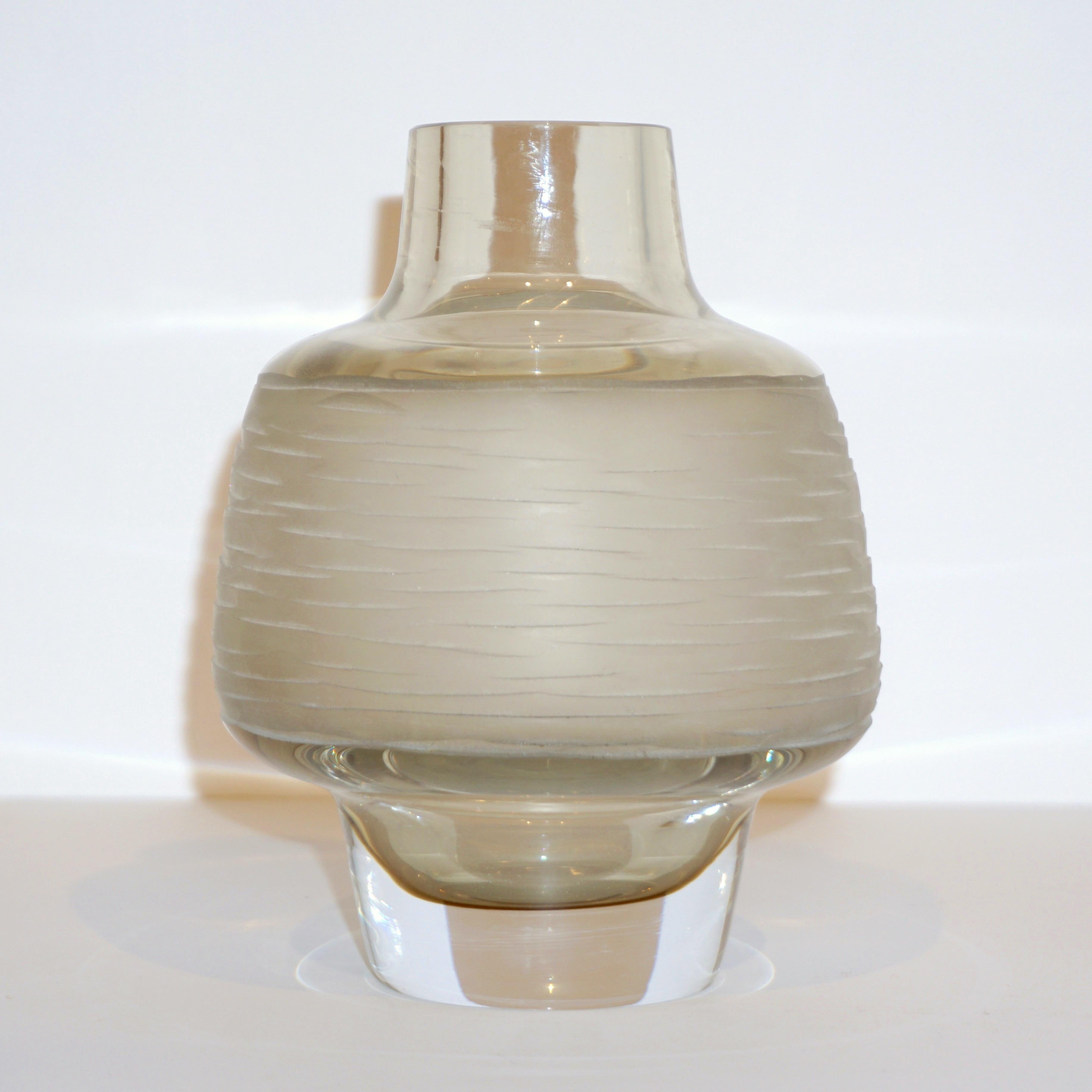 1970s elegant Venetian small flower vase of organic round shape, finishing with a clear collar neck, blown by Formia in Sommerso Murano glass with a refined smoked light amber beige color highlighted by a delicate pink rose reflection and overlaid