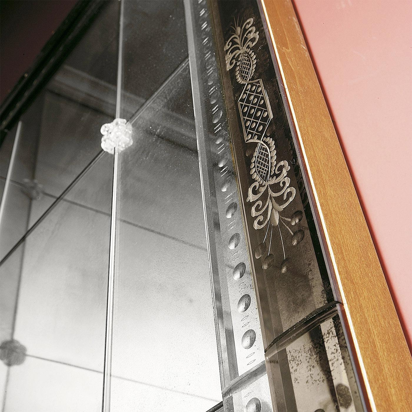 Faisant partie de la Collection Venetia et fabriqué à la main selon l'ancienne tradition vénitienne, ce miroir majestic est décoré de la gravure de motifs floraux. Structure en bois avec finition couleur noyer. Carreaux de verre biseautés centraux