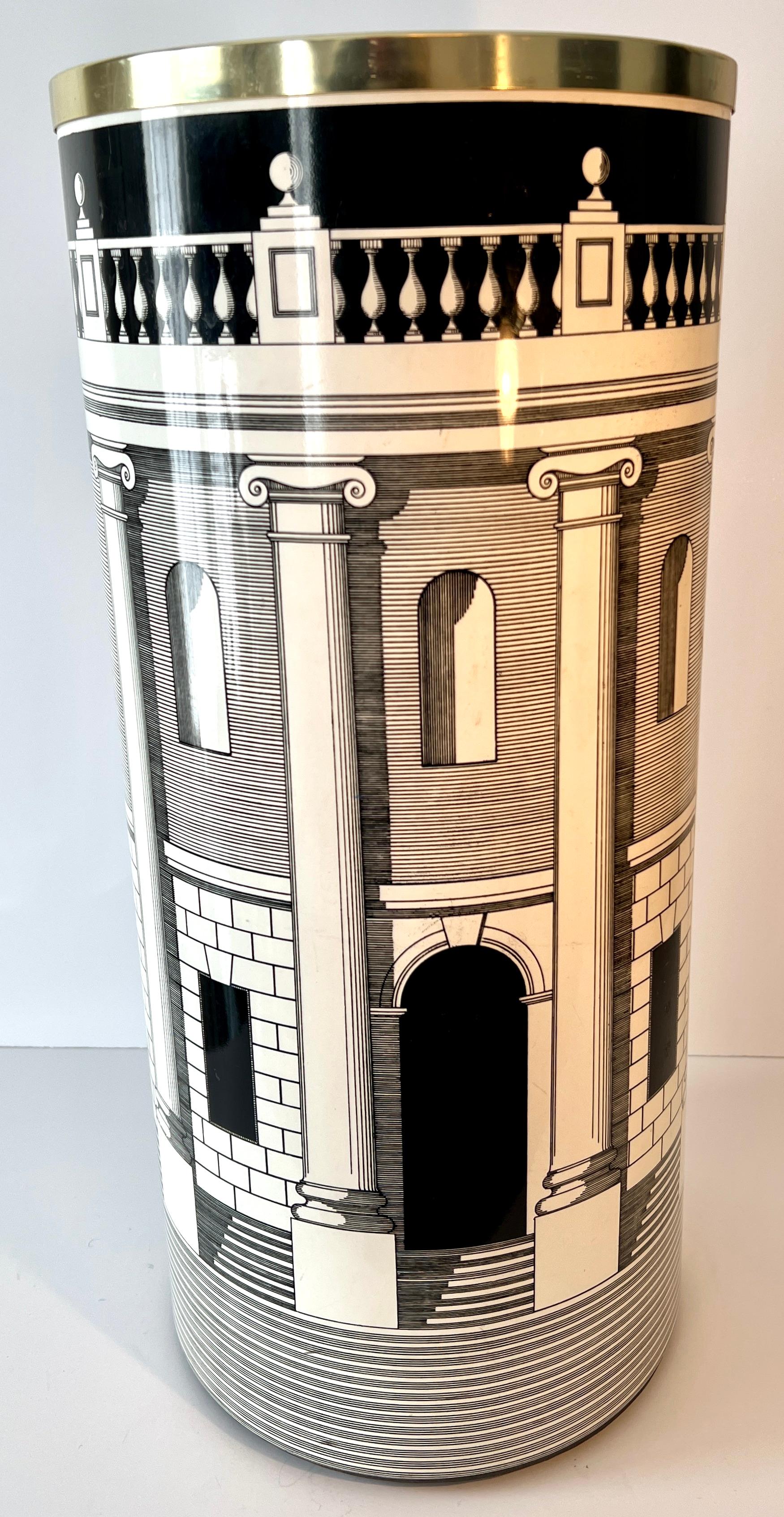 A stunning metal Umbrella Stand with the iconic Architettura Pattern.  The size and presence is large enough, not only to work well with Umbrellas, but can also work as a waste or laundry bin - it's Fornasetti, give your self license to expand and