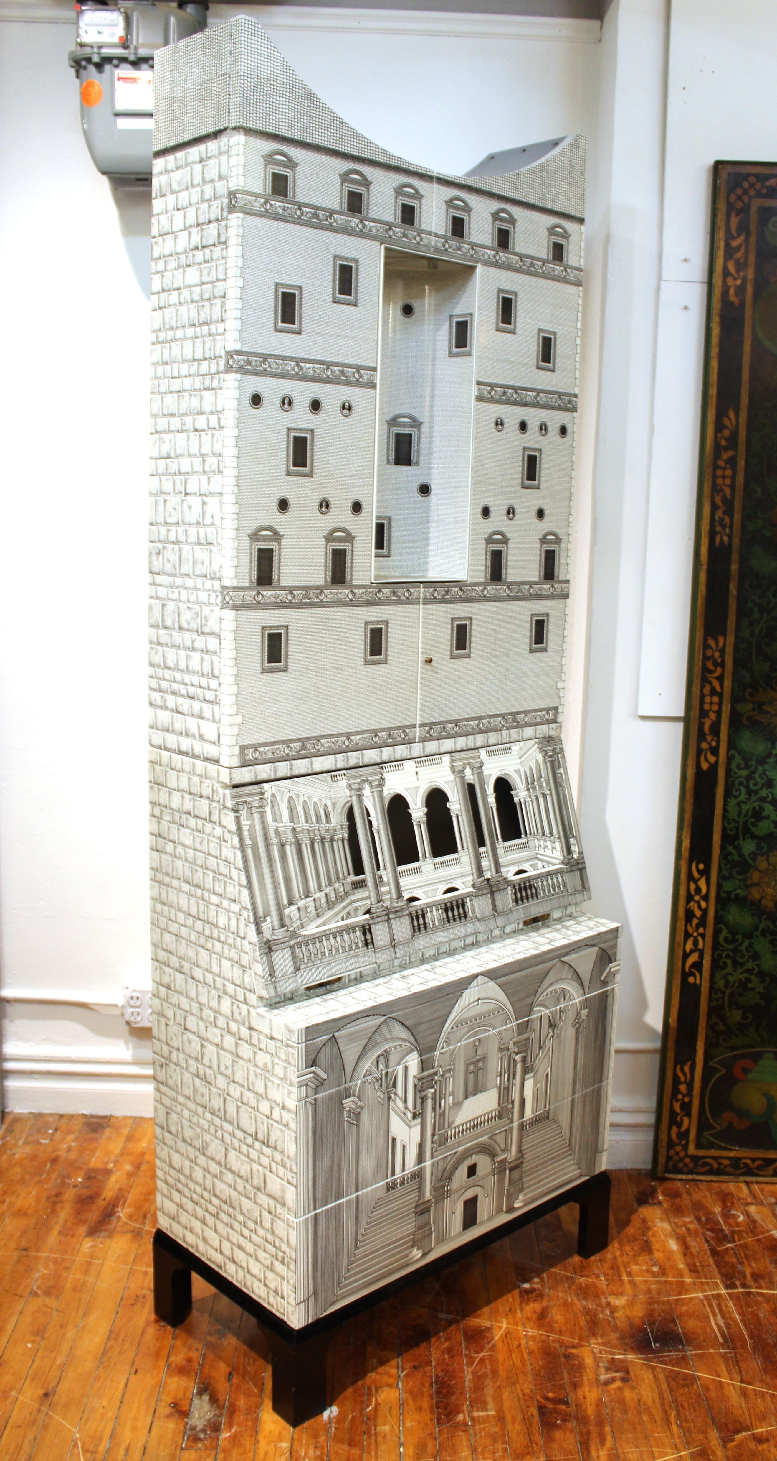 Italian modern Fornasetti 'Architettura' trumeau with concave top and illuminated niche. The piece has a wooden structure, lacquered and printed with 18th century inspired lithographs of Italian palaces such as the Alessi Palace in Genoa.
This