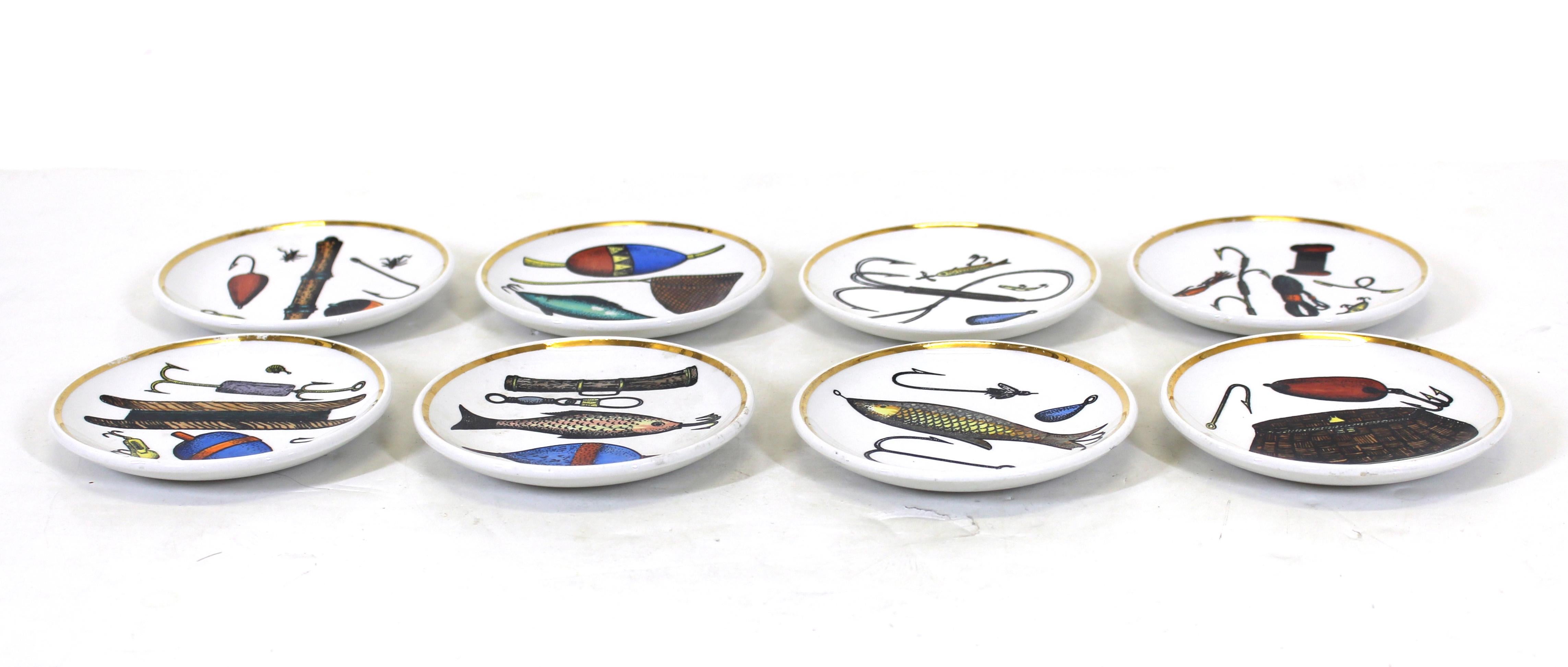 Set of eight Rosenfeld Imports coasters with a sportsman or fisherman theme in silver, gold and multicolor ceramic, made in Italy, likely by Fornasetti during the 1960's. The bottoms are marked 'Made in Italy for Rosenfeld imports'. Fornasetti