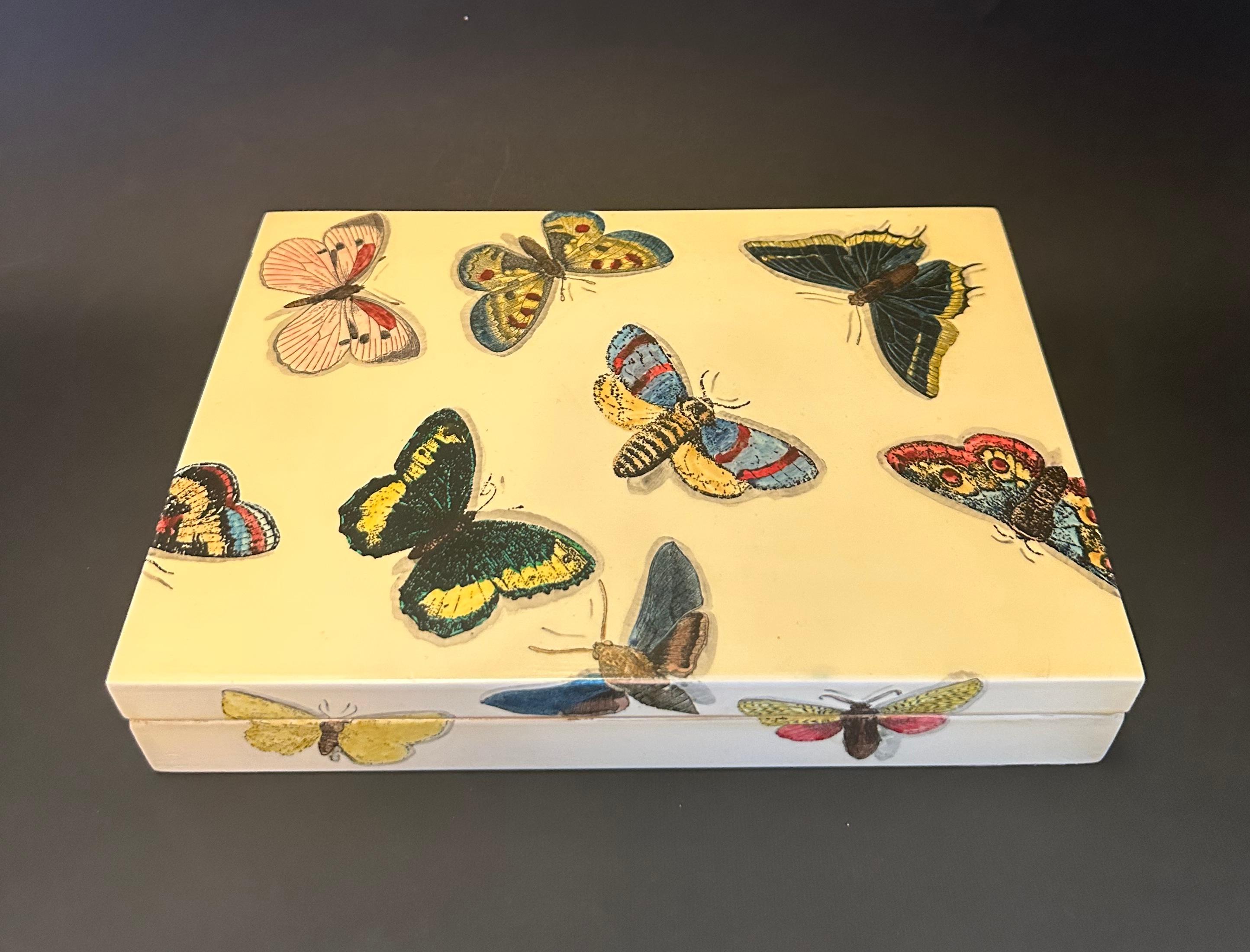 Boîte de jeu de poker papillon vintage, sérigraphie sur bois, avec deux jeux de cartes, huit dés et des jetons / Design/One, fabriqué à Milan Italie par Fornasetti
Label original sur la base
Longueur : 9 pouces / Largeur : 6.5 pouces / Hauteur : 2