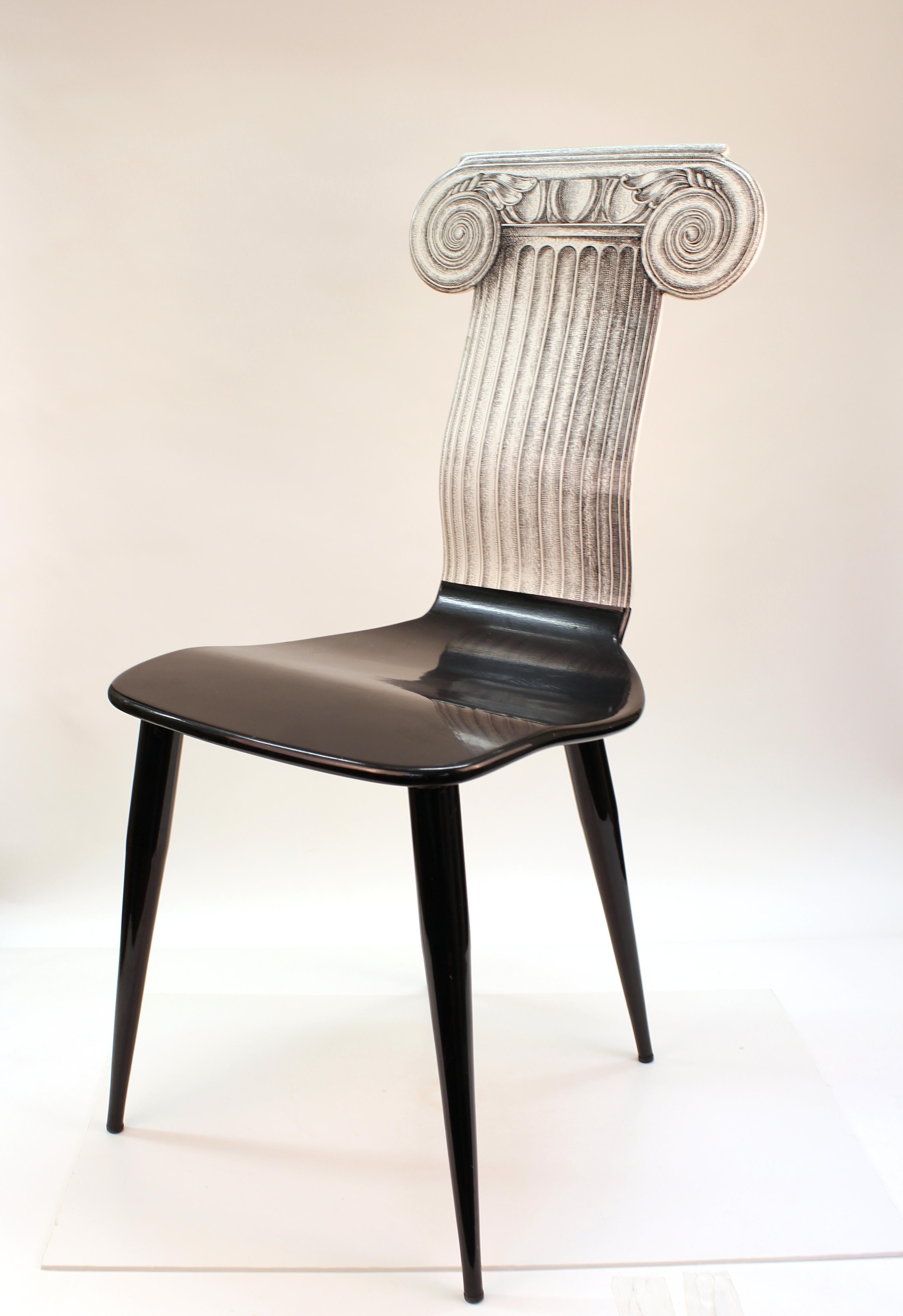 Fornasetti 'Capitello Ionico' lacquered wooden chair in black with enameled metal legs and a lithographically applied graphic of the upper section of a classical Ionic order column on its back. The piece has a label and number (18H). In great