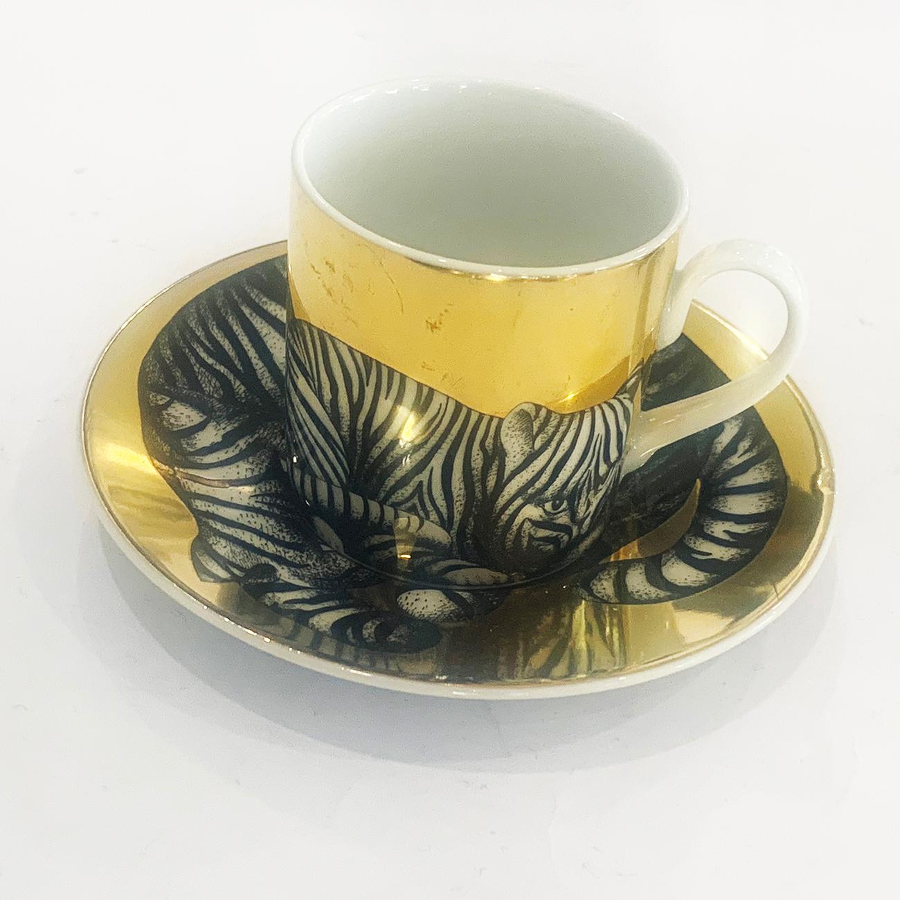 Fornasetti coffee cup and saucer with decoration of a black and white cat in stripe pattern and heavy gold finish on the fine, white Porcelain. Both pieces are factory marked to the rear or base, under licence to Royal Rosenthal, Germany and also