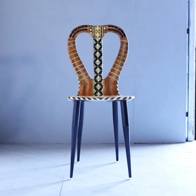 A “Musicale” chair by Atelier Fornasetti. Lithographically printed. Hand colored wood, lacquer, metal tubular legs.