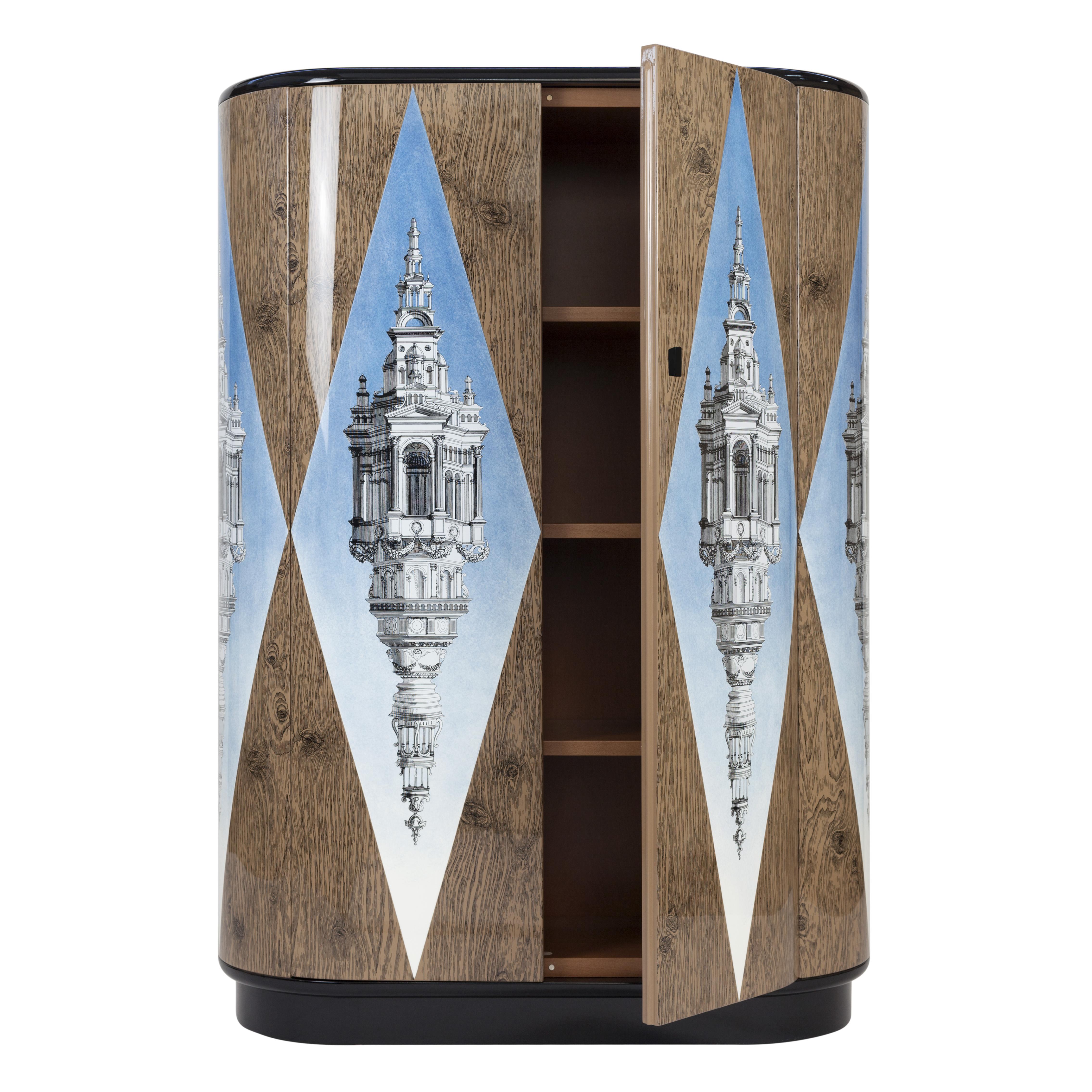 The curved cabinet shape was designed by Barnaba Fornasetti in 2003 and now it can be considered one of the most iconic pieces of furniture in the Italian atelier's collection. 

Like all Fornasetti pieces of furniture, it is hand-crafted using