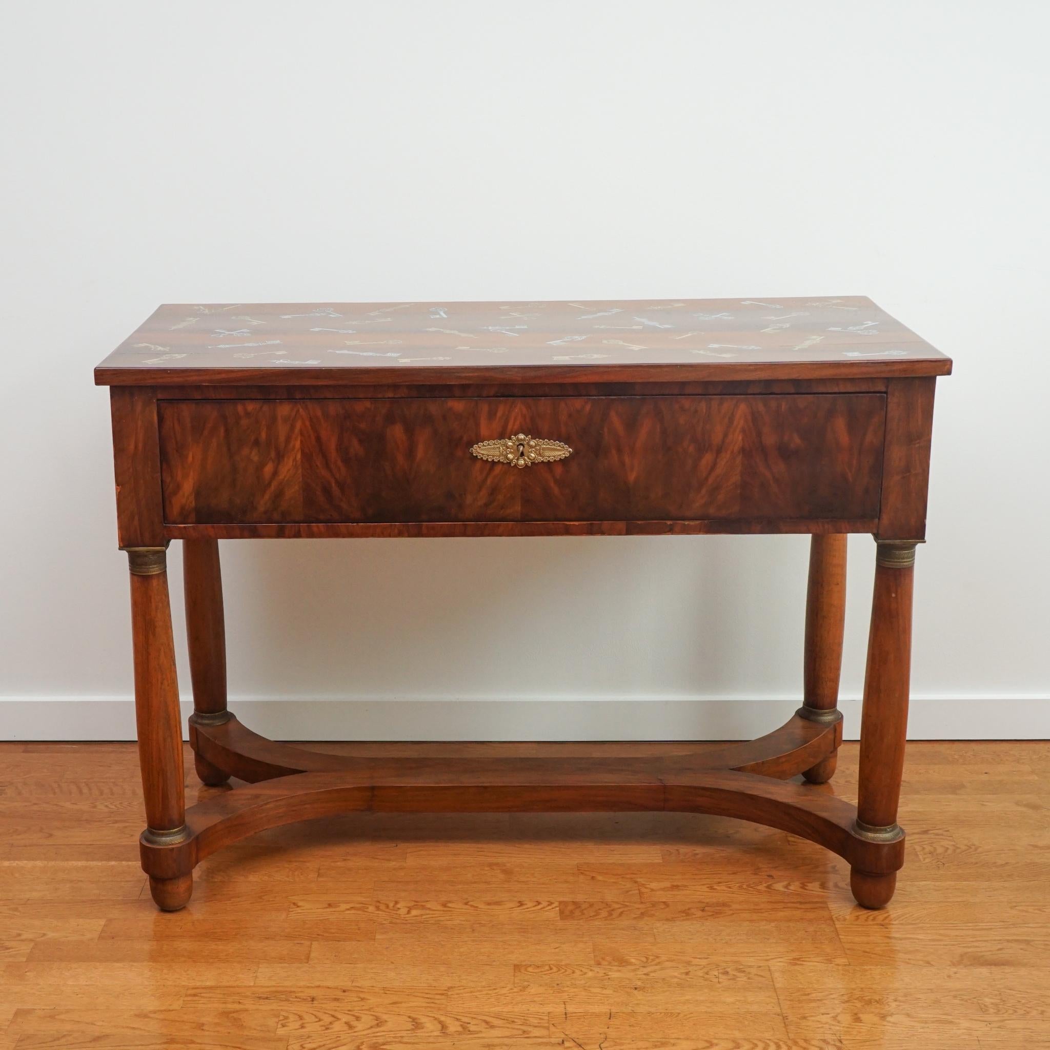 L'exquise table bureau antique, présentée ici, représente la première collaboration entre foley&cox HOME et Fornasetti. Le bureau a été acheté en Italie et décoré à la main par Fornasetti à l'aide d'un motif d'archives composé de clés squelettes