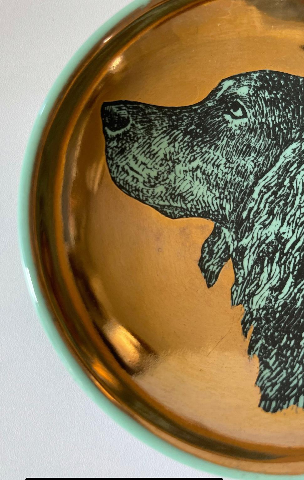 Die Portman Gallery (Brooklyn, NY) bietet diesen hohlen, konkaven Hundenapf von Fornasetti aus Keramik an, grün glasiert und vergoldet, in sehr gutem Zustand.

Ich habe noch nie einen Napf wie diesen in a) so gutem Zustand und b) mit zwei anderen