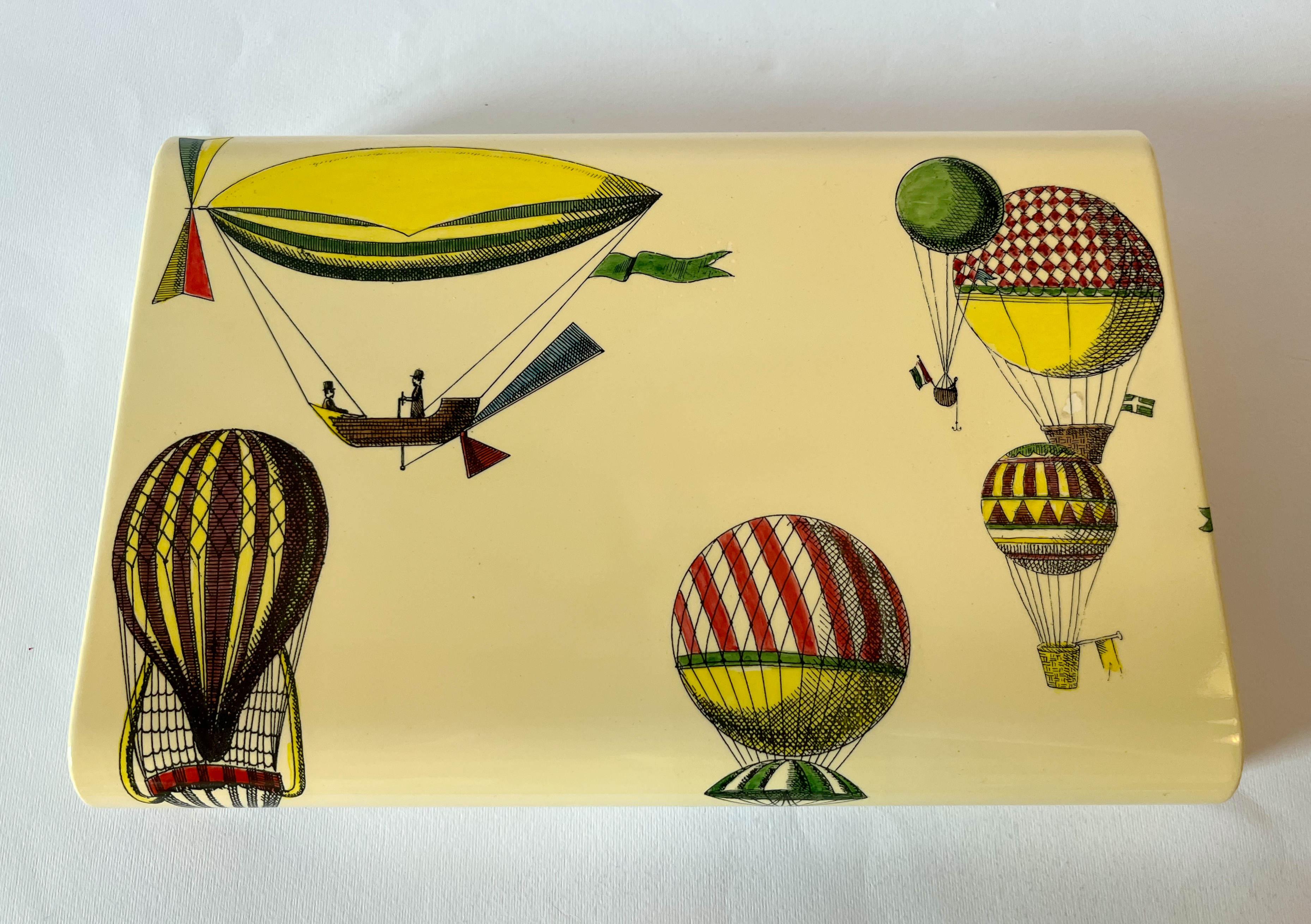 Boîte de jeu de poker en montgolfière vintage, sérigraphie sur bois, avec deux jeux de cartes, huit dés et des jetons / Design/One, fabriqué à Milan Italie par Fornasetti
Label original sur la base
Longueur : 12 pouces / Largeur : 8 pouces / Hauteur