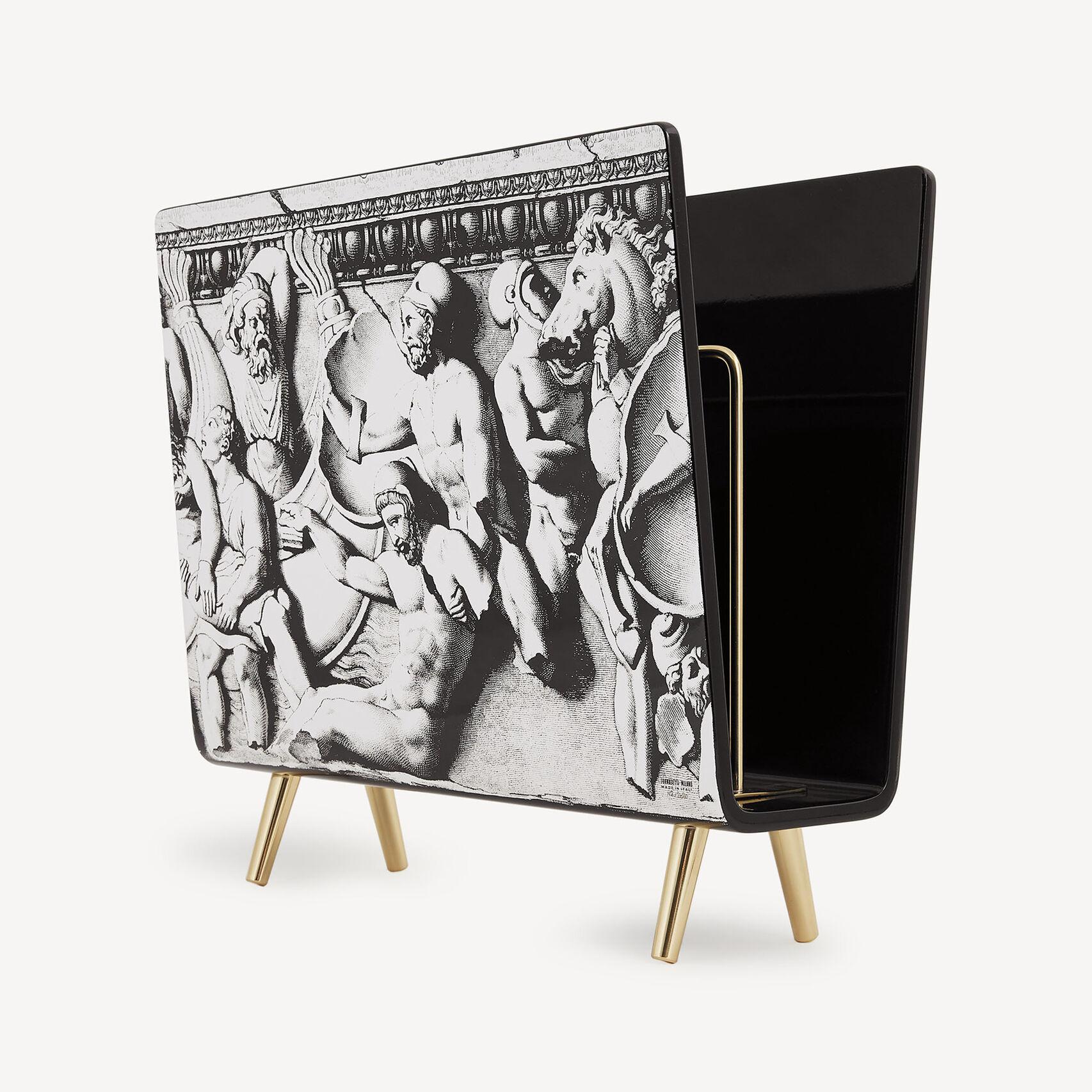 l suo sorprendente portariviste Fornasetti mette in mostra l'inconfondibile fusione di arte classica, arguzia surrealista e raffinato artigianato decorativo dell'Atelier A.

Il pannello frontale presenta un'intricata illustrazione litografica in