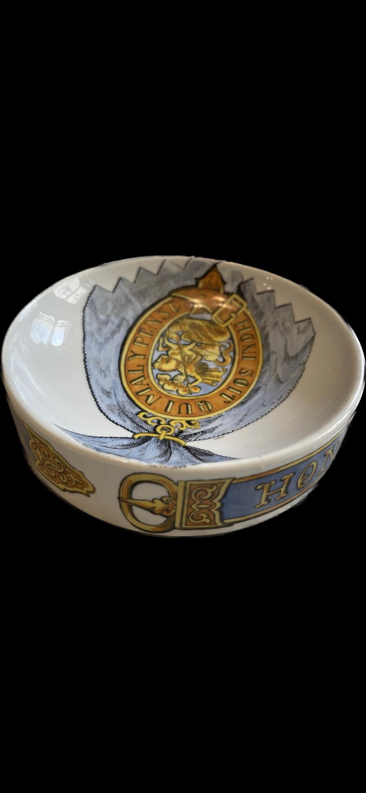 Yellow and blue hand painted ceramic concave transferware ashtray from Piero Fornasetti, designed and produced in the 1950s-1960s. Pictured among its other variations in the Fornasetti Complete Universe book on p. 577. Very good condition, a bit