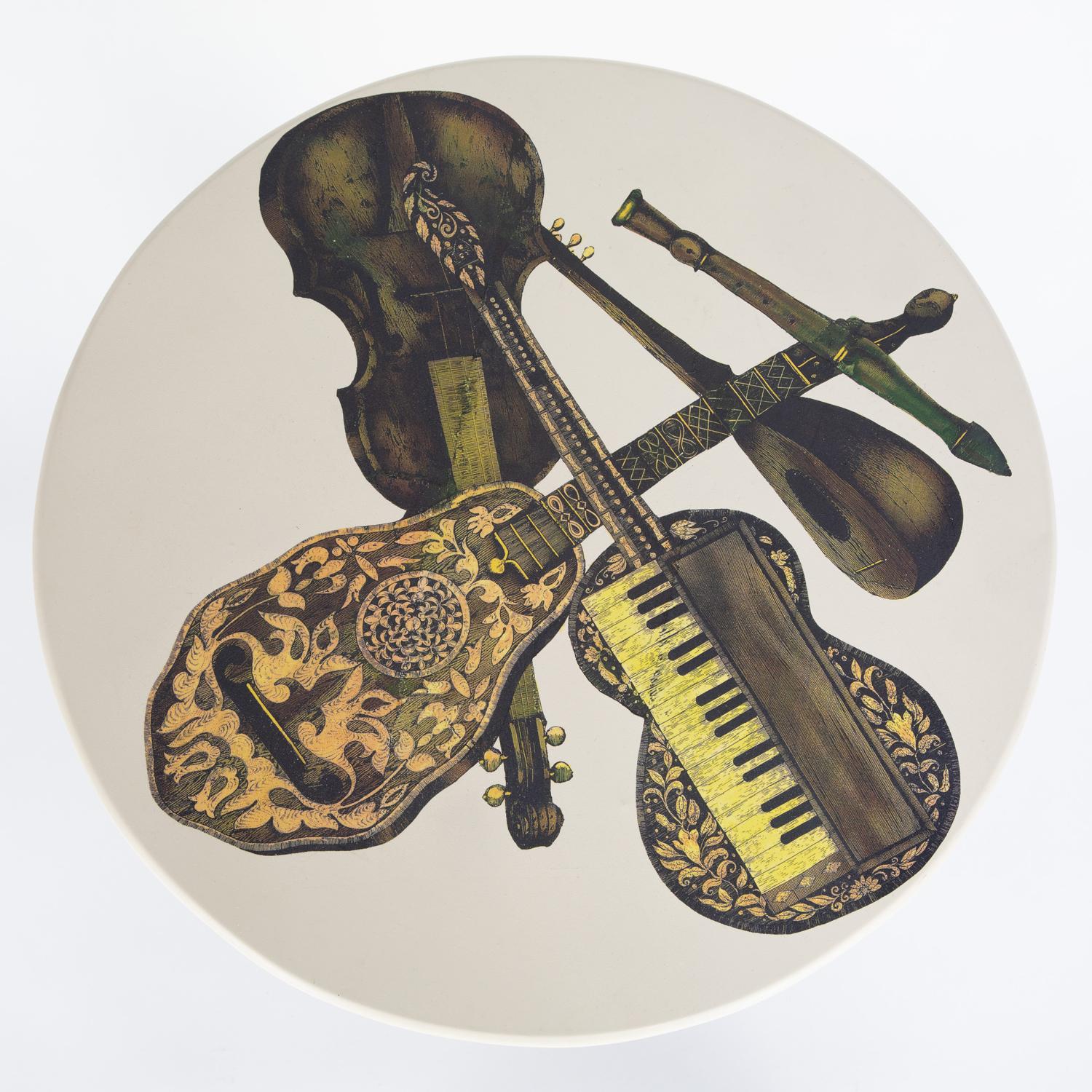 Pair of round side tables, tops with musical instruments motif and bases in brushed brass, by Piero Fornasetti, Italy, 1950's (labels on bottom read “Fornasetti-Milano”). Bases have been cleaned and polished.
