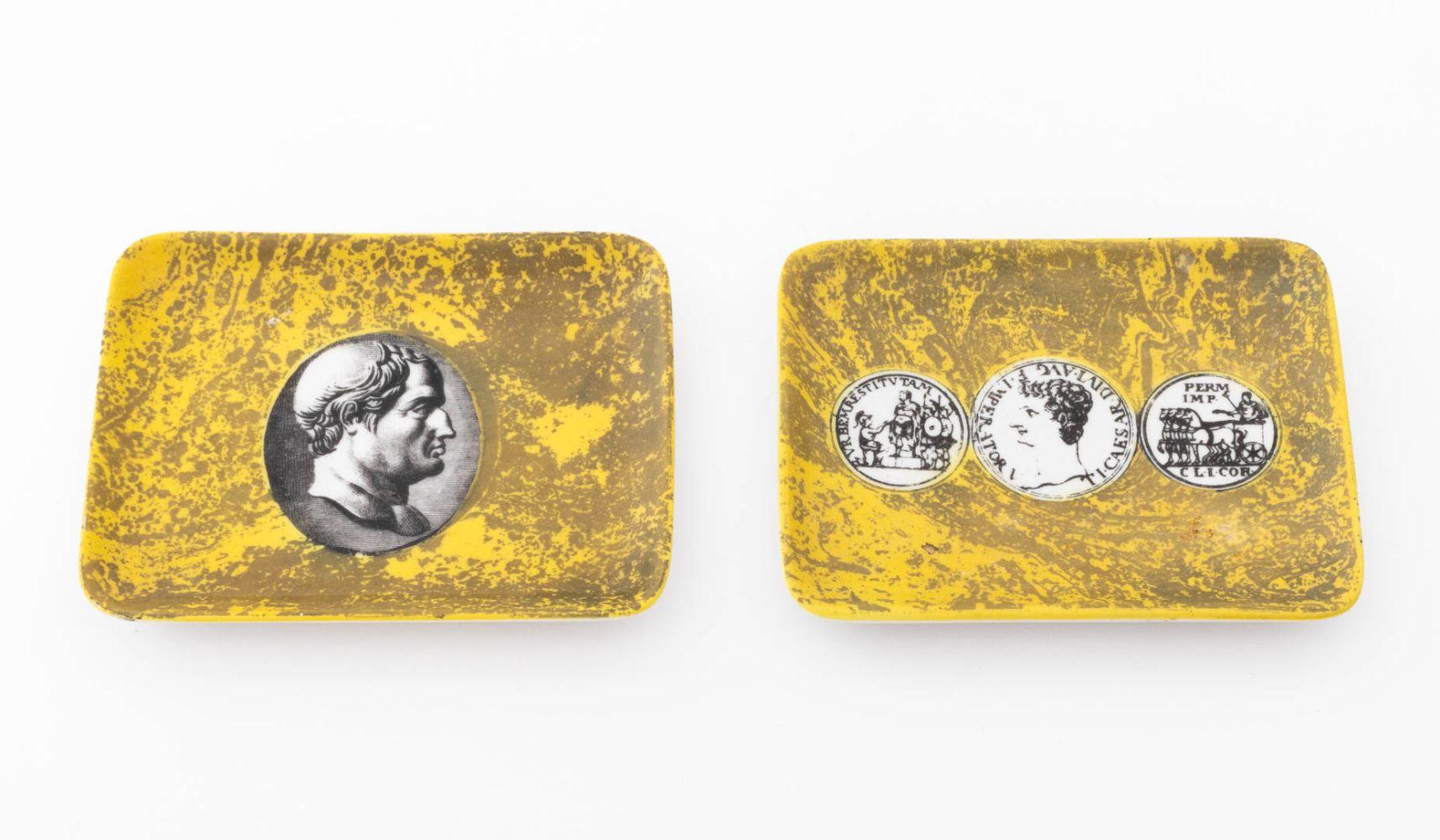 Two Fornasetti Porcelain Rectangular Trays, comprising: one with Theodor Galle printed portrait to the center and  one with three Roman coins printed to the center, each with glazed yellow faux marble background.

5.5