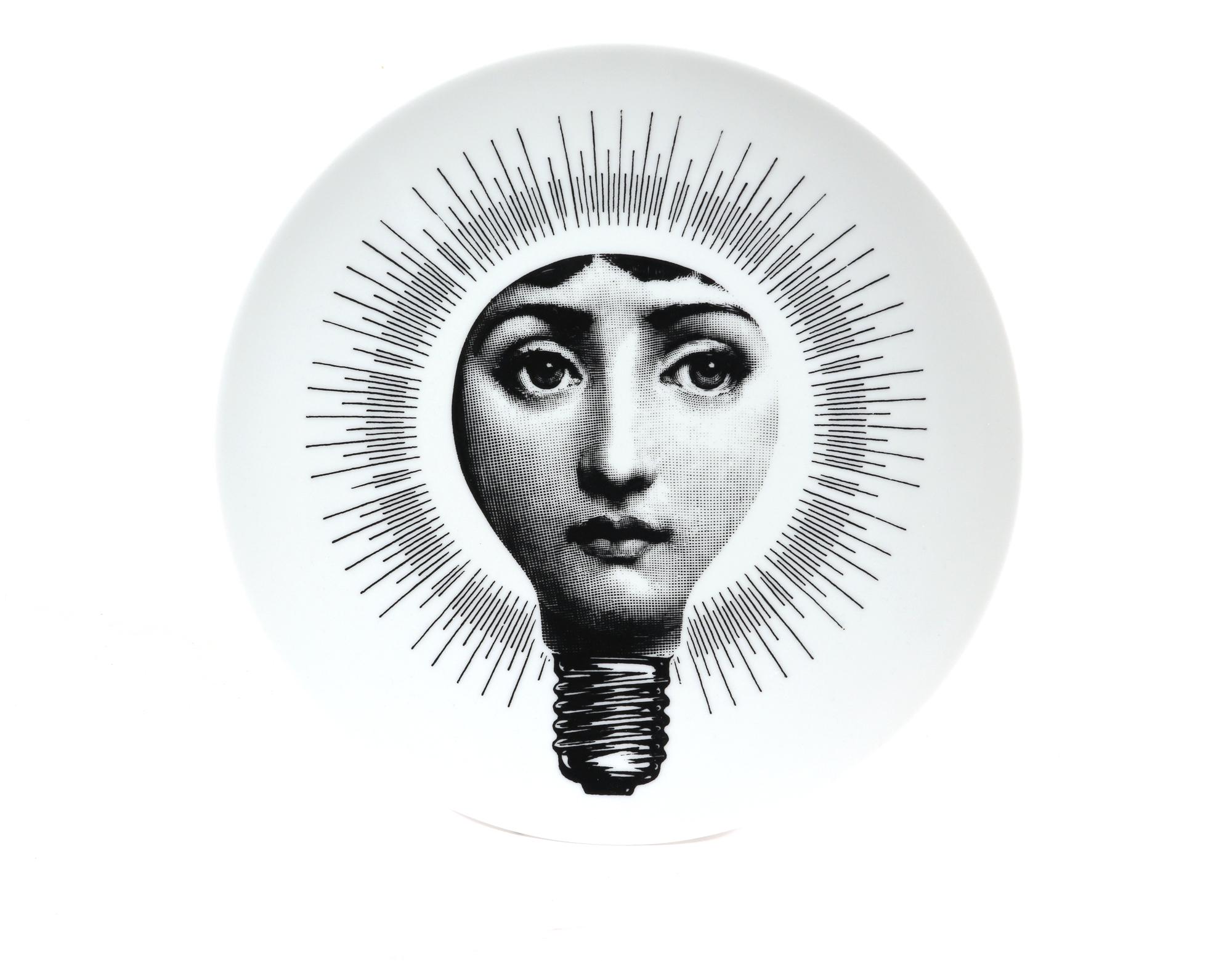 Fornasetti Porcelain Surrealist Themes & Variation Plate #83,
The Light Bulb,
Atelier Fornasetti

The Surreal Fornasetti porcelain plate in the Themes & Variation pattern depicts the face of Lina Cavalieri, Piero Fornasetti's muse in a light