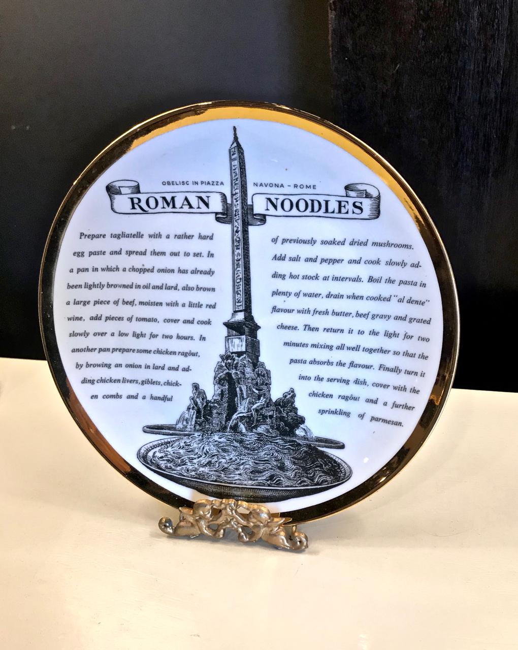 This is a superb set of eight Fornasetti Recipe plates (English Version). The plates depict various Italian cities and monuments and each carries a recipe for a culinary regional favorite. The plates are rimmed with a gold band.