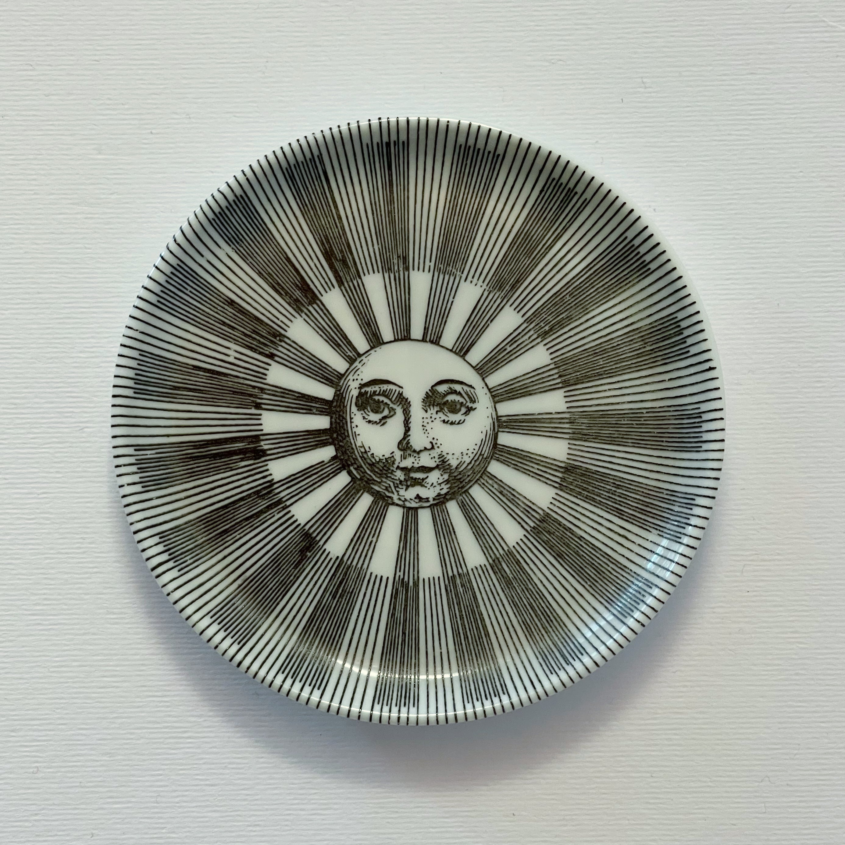 Vintage Piero Fornasetti small porcelain dish or plate depicting a face on the moon with light rays of a sun, no. 4 from series 