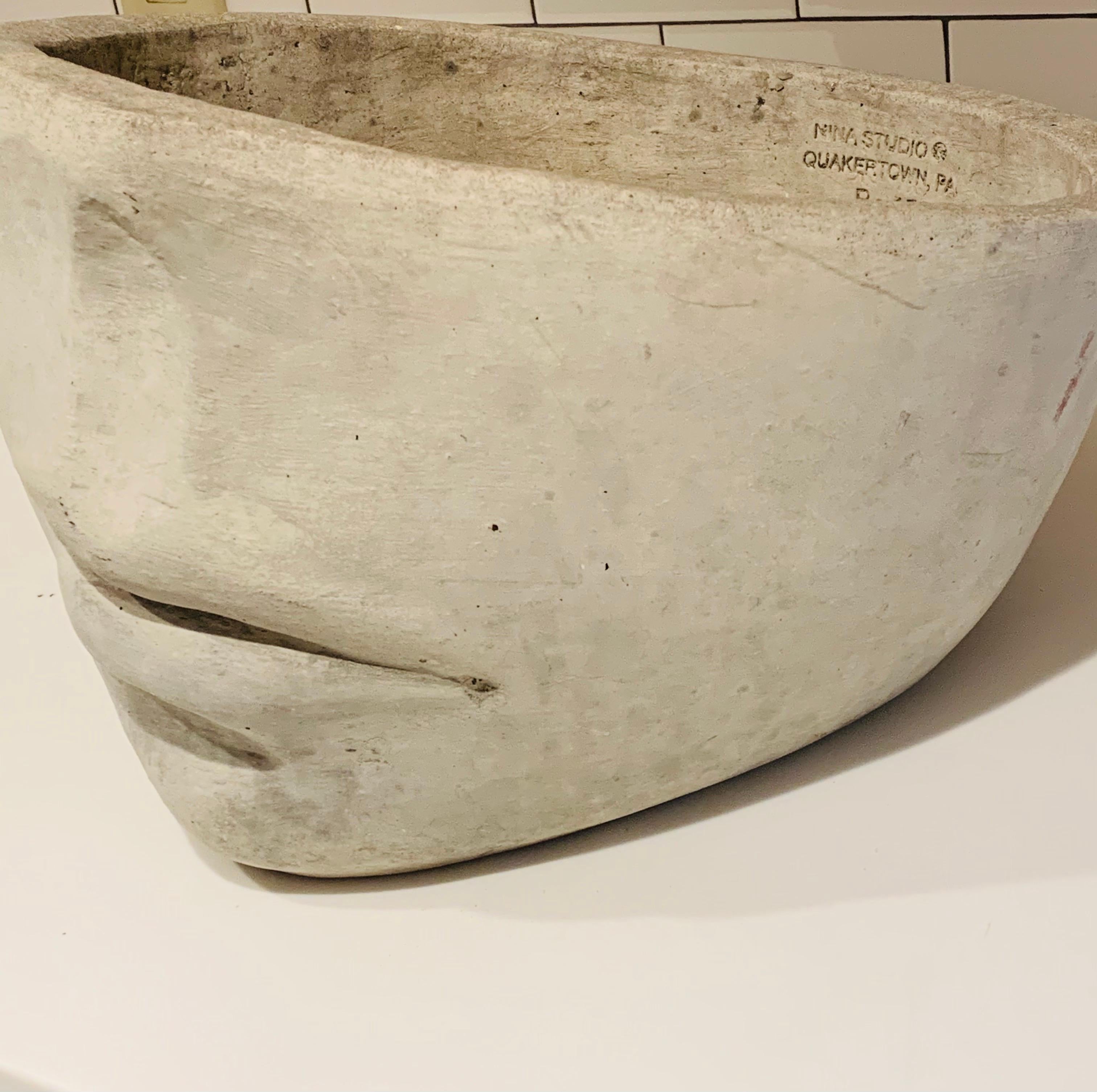 This cast-concrete vessel was designed & produced in the 1970's by Nina Studios in Quakertown, Pa.

There have been many other half-faced planters made, but the proportions never look quite right. 

Its rather scarce to find the original in this