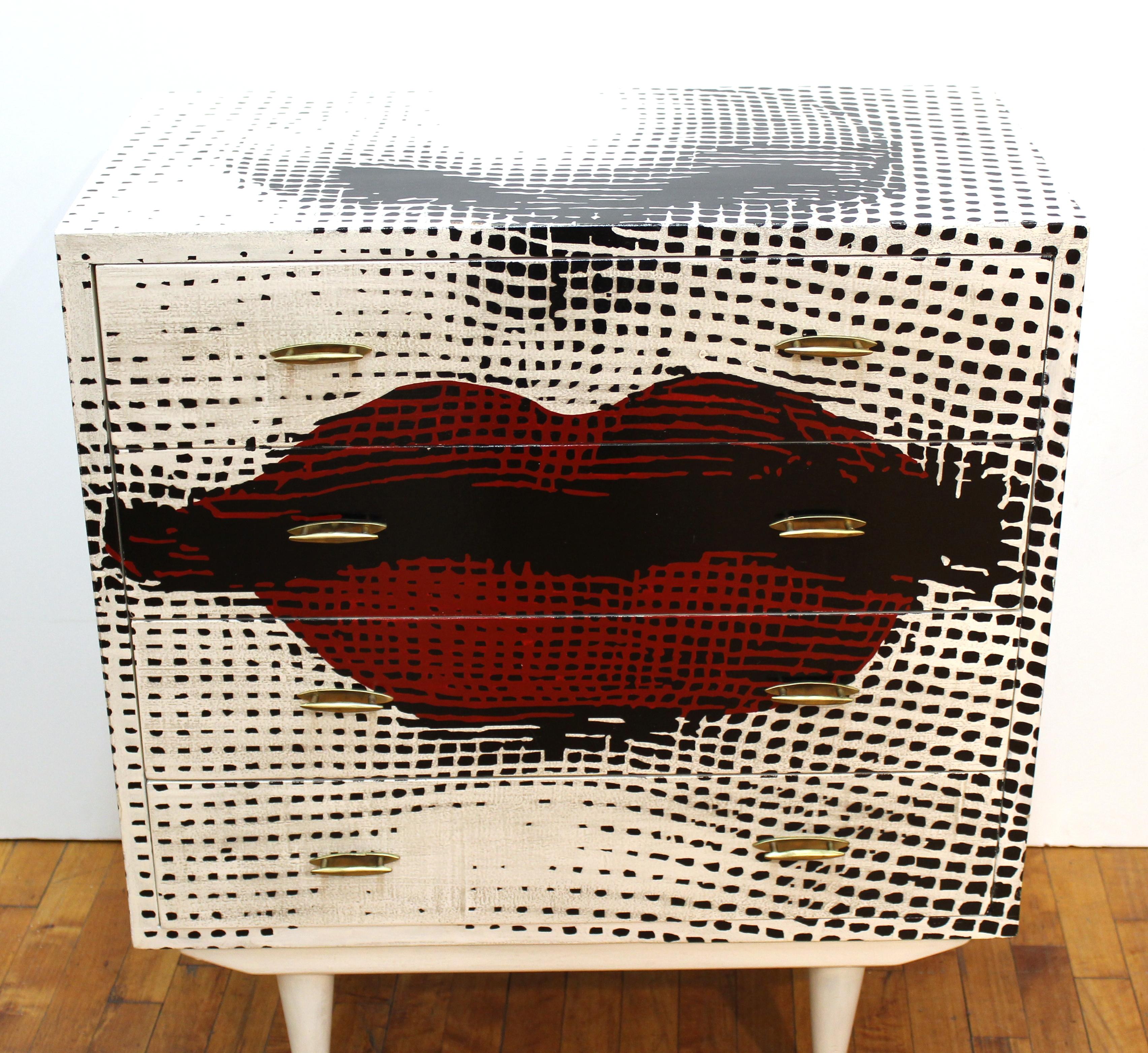 Mid-Century Modern black, white and red four drawer chest with nose and red lips. The chest has brass pulls and brass capped legs, and was made during the 1980's in Italy. In very good vintage condition with age-appropriate wear and use. The drawer