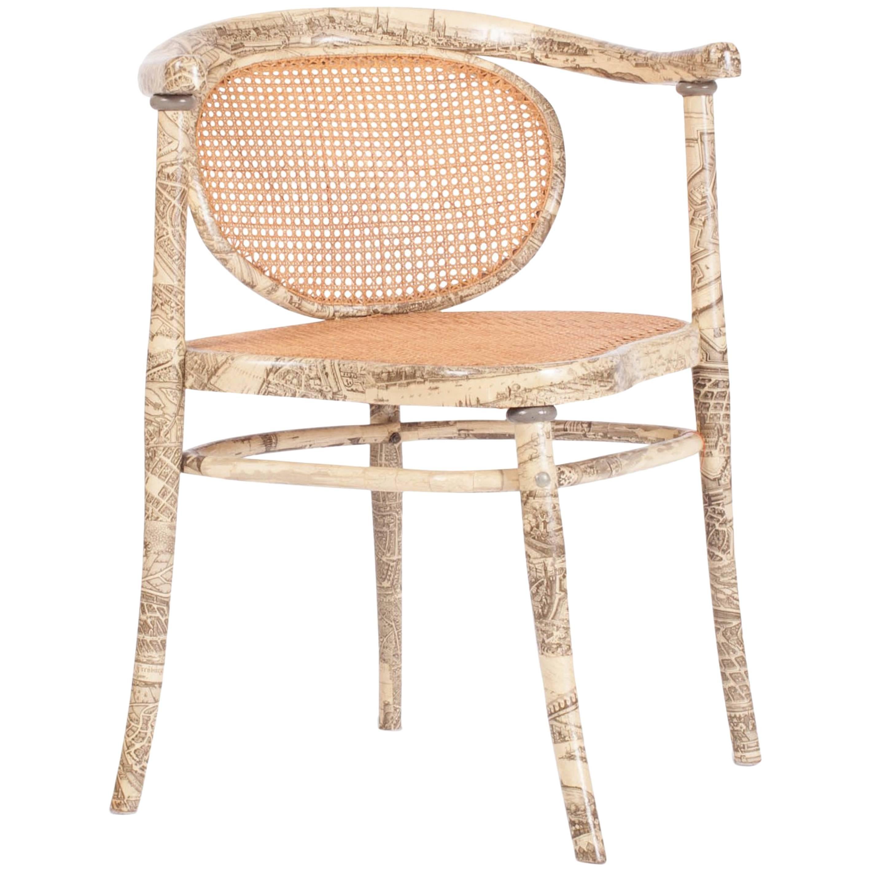Thonet armchair with a printed illustration. 

The seat and backrest are weaved in rattan. The rest of the frame is covered in a print
that could have influenced by the great Fornasetti. The chair is marked on the inside of the seat.

Europe,