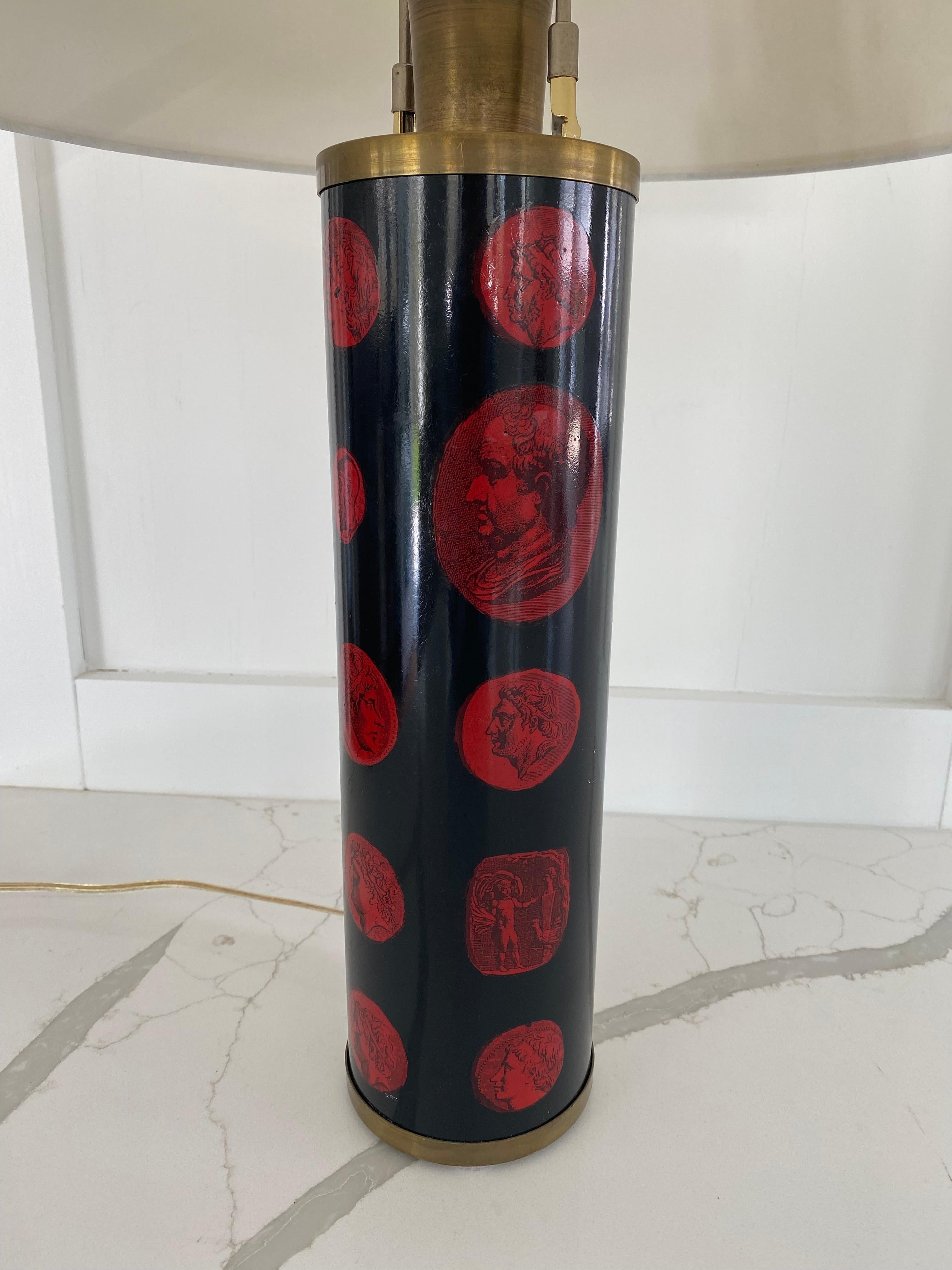 Classic Fornasetti lamp with black ground and red cameo pattern.