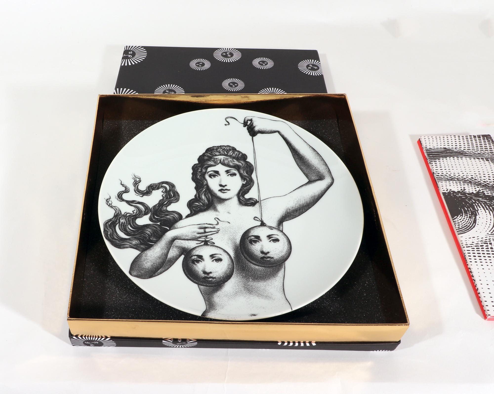 Fornasetti Themes & Variations Porcelain Plate, # 182,
Atelier Fornasetti

The Fornasetti porcelain plate in the Themes & Variation pattern depicts a surreal image of a naked Greek Goddess figure with her hair flowing across her right shoulder