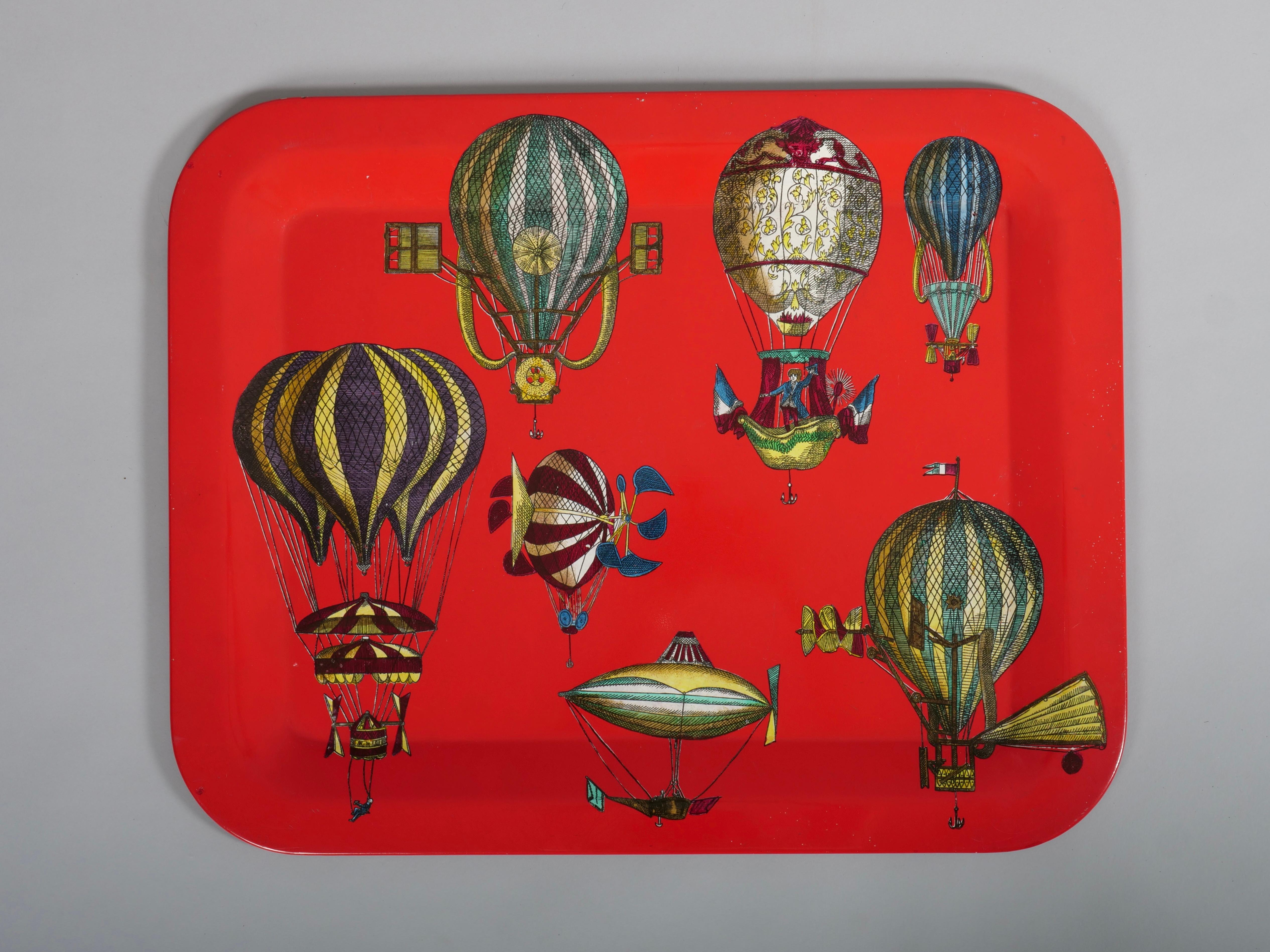 Merveilleux plateau original des années 1950 de Piero Fornasetti avec des motifs fantastiques de montgolfières sur fond rouge.

Peinture à la main, lithographie 