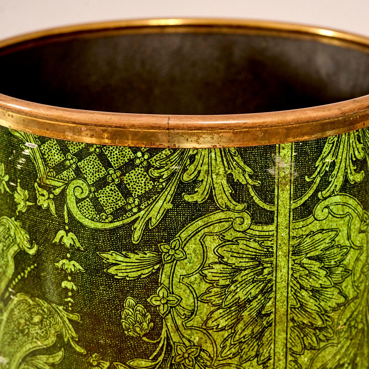 Fornasetti waste bin. 
Baroque pattern lithographic transfer, and lacquered metal. Green on black ground. With brass trim and brass feet.  

Stamped on underside 'Fornasetti'