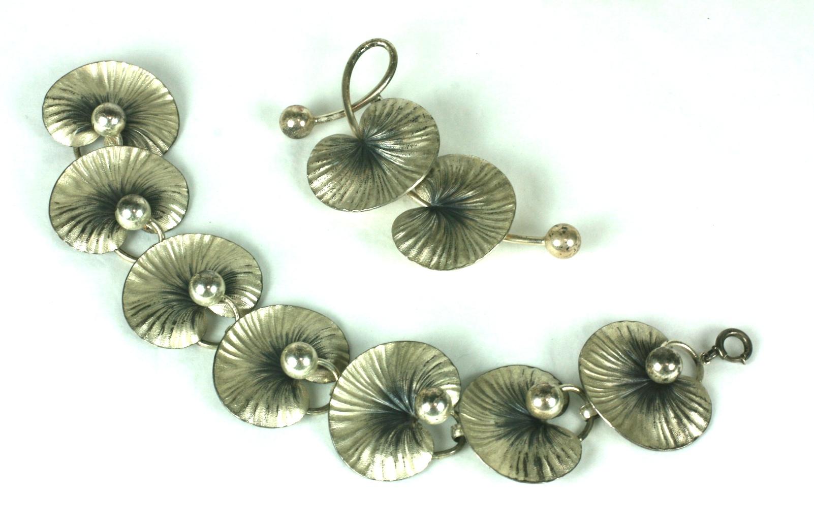 Forstner Arts and Crafts patinaed  sterling silver lily pad parure. Consisting of a link bracelet, brooch and earclips.
Excellent Condition, Signed. 
Bracelet  Length 7. 25