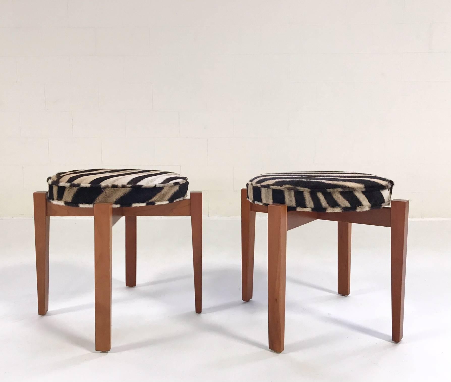 This set of walnut stools was designed in 2007 by Jens Risom for Ralph Pucci. They were originally designed for Philip Johnson's Glass House in New Canaan, CT. Expertly restored and reupholstered in zebra hide, these stools are amazing, a beautiful