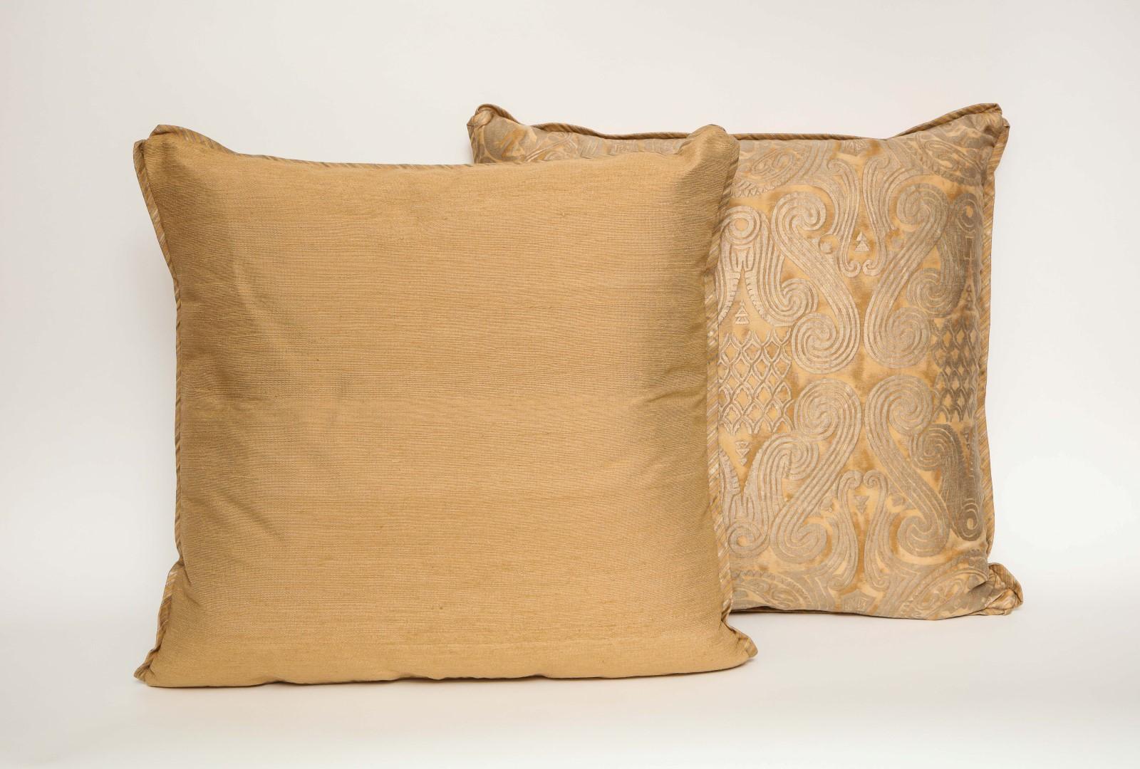A pair of Fortuny fabric cushions in the Peruviano pattern, tan and silvery gold color way with silk bias edging and taffeta backing material, the pattern, a Peruvian inspired design with scroll motif. Newly made.

50 down/50 feather insert.
 