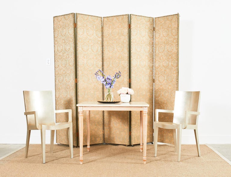 Gorgeous Fortuny silk damask upholstered folding screen or room divider. Bespoke professionally crafted screen features five panels painstakingly constructed with brass tack nail heads around the border and sage green silk brocade edges. The panels