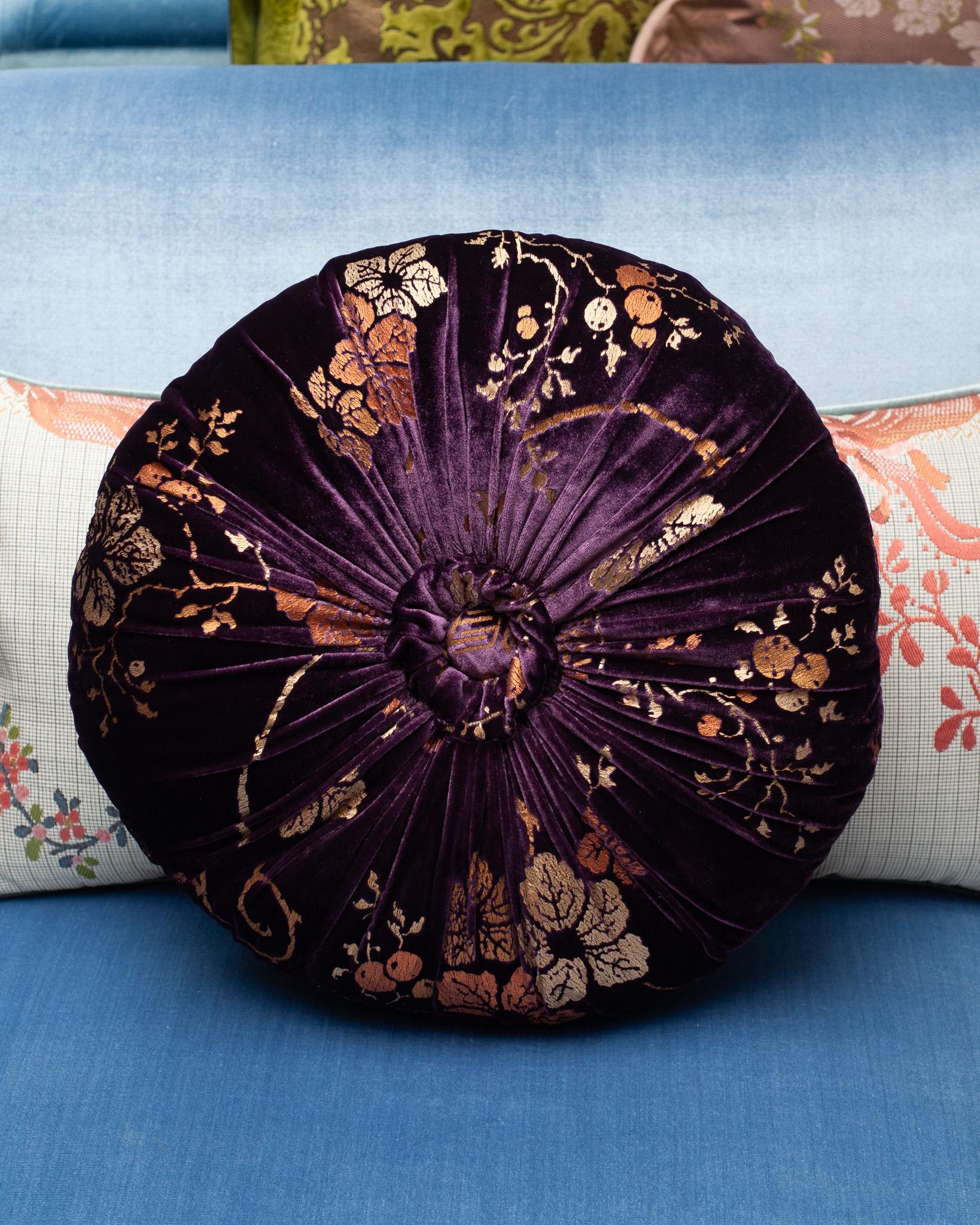 A beautiful Fortuny / Venetia Stadium round pillow with pleats and a center tuft in deep purple velvet with gold, made in Venice.

Mario Fortuny was born in 1871 in Granada Spain and after a childhood marked by the premature death of his father he