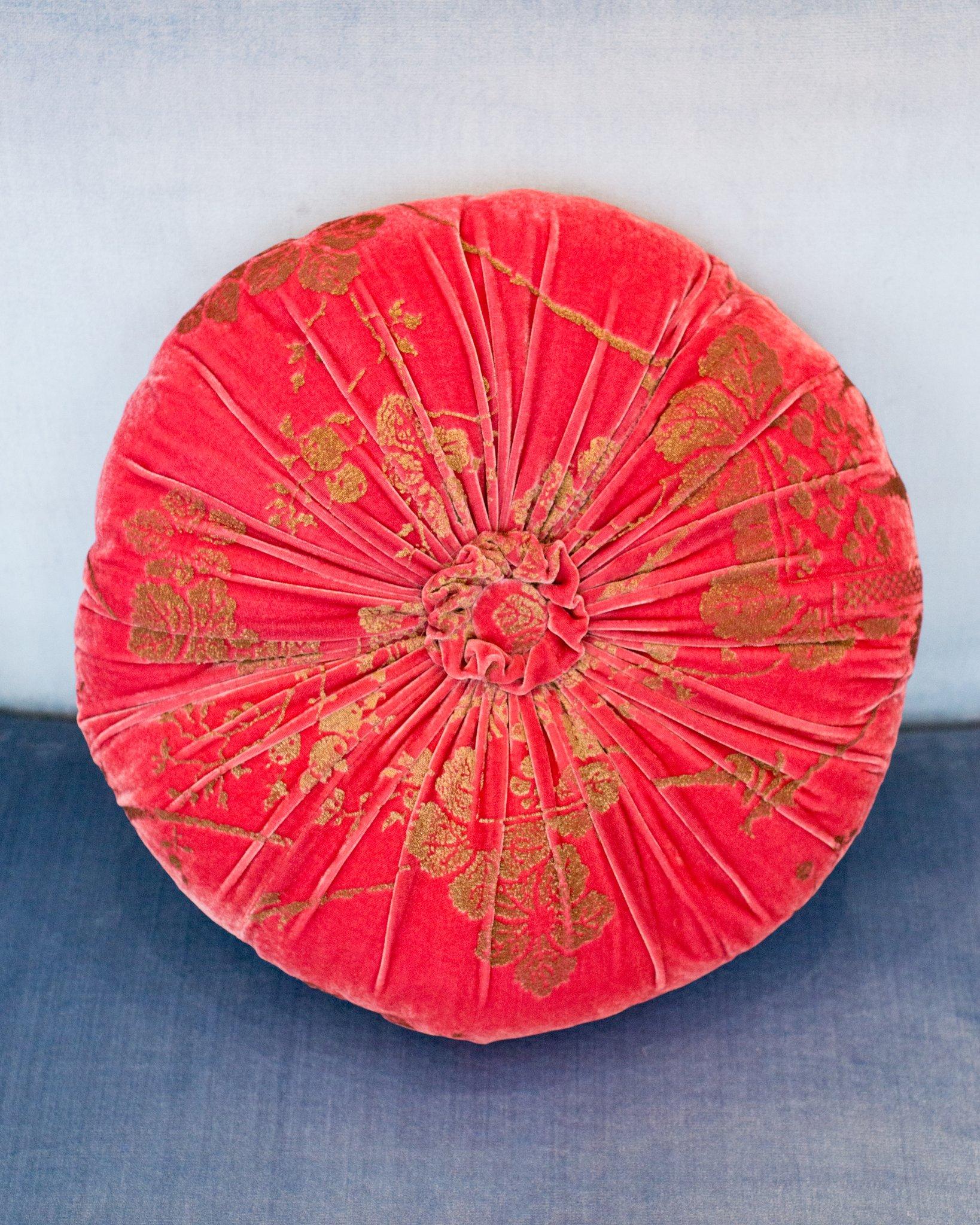 A beautiful Fortuny / Venetia Stadium round pillow with pleats and a center tuft in strawberry pink velvet with gold, made in Venice.

Mario Fortuny was born in 1871 in Granada Spain and after a childhood marked by the premature death of his father