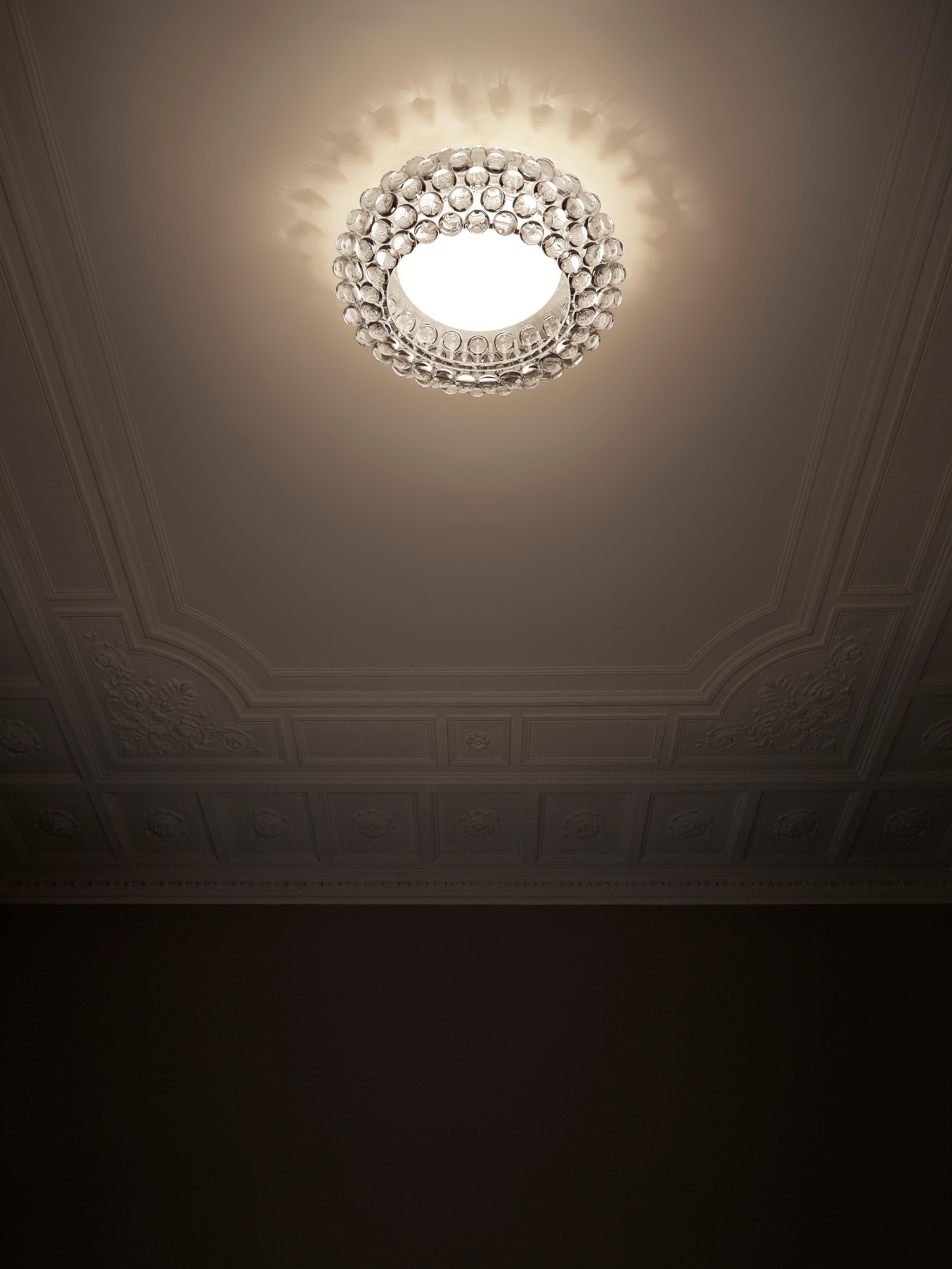 Like a bracelet of sparkling transparent pearls, the Caboche ceiling lamp embellishes any room with its extraordinary lighting effect, where each sphere reflects the image of the light source inside the central diffuser, creating games of light onto