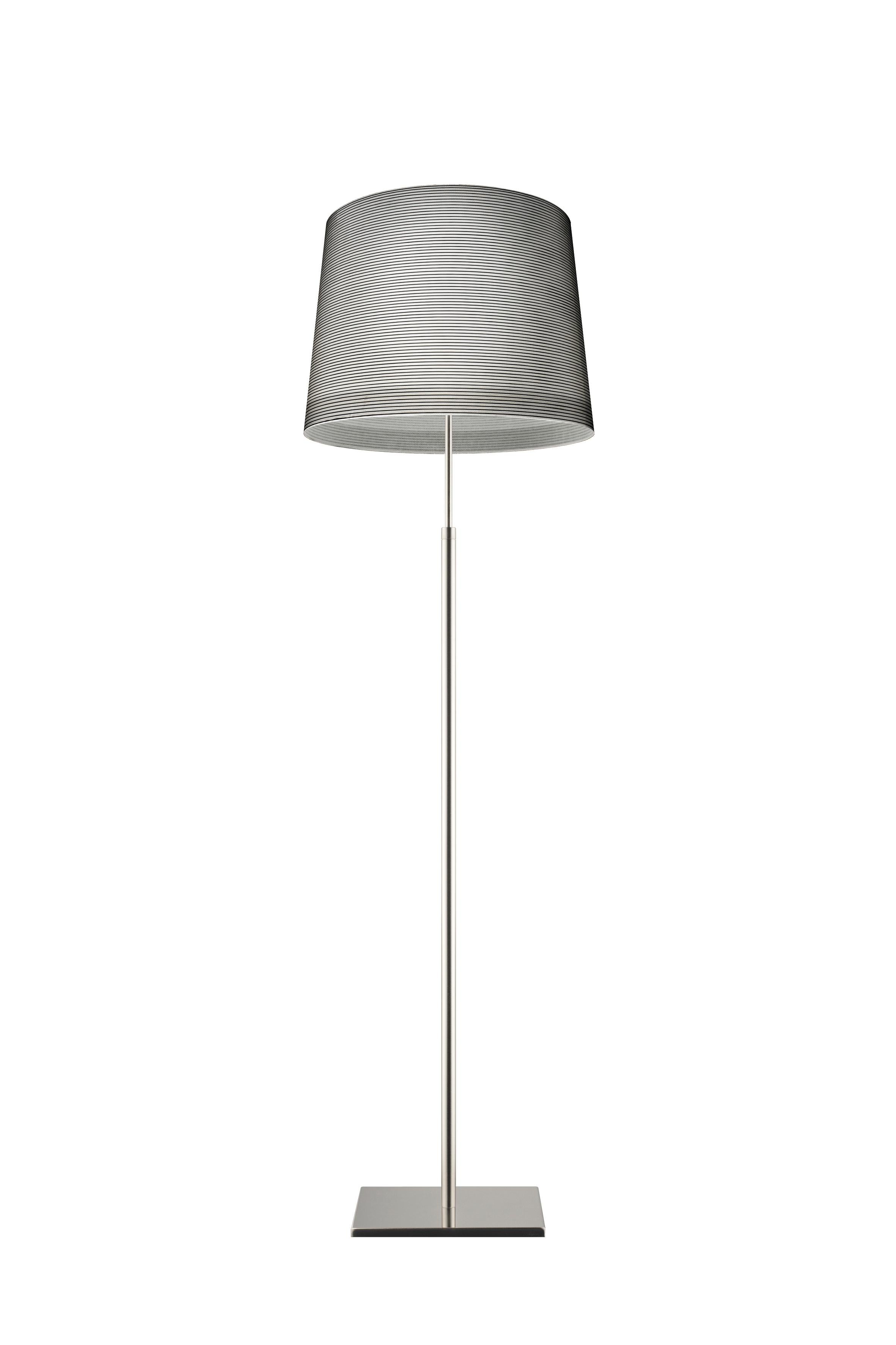 Floor lamp with diffused and direct light. Diffuser achieved using an artisanal process that entails the application of a carbon thread onto a glass fabric. Brushed stainless steel telescopic rod which can be extended by approximately 10 inch. with
