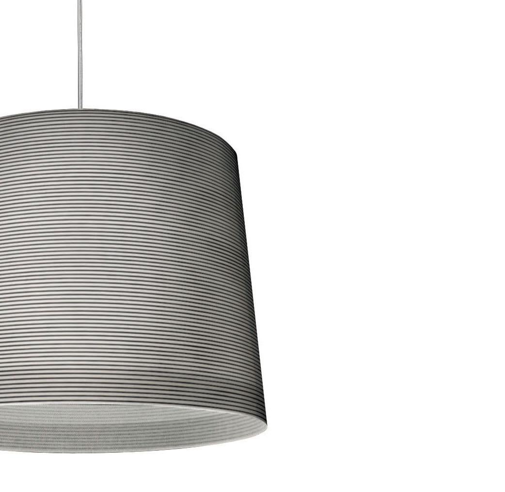 Suspension lamp with diffused and direct light. Di user achieved using an artisanal process that entails the application of a carbon thread for the black version onto a glass fabric. Brushed steel mount with transparent protective coating. Ceiling